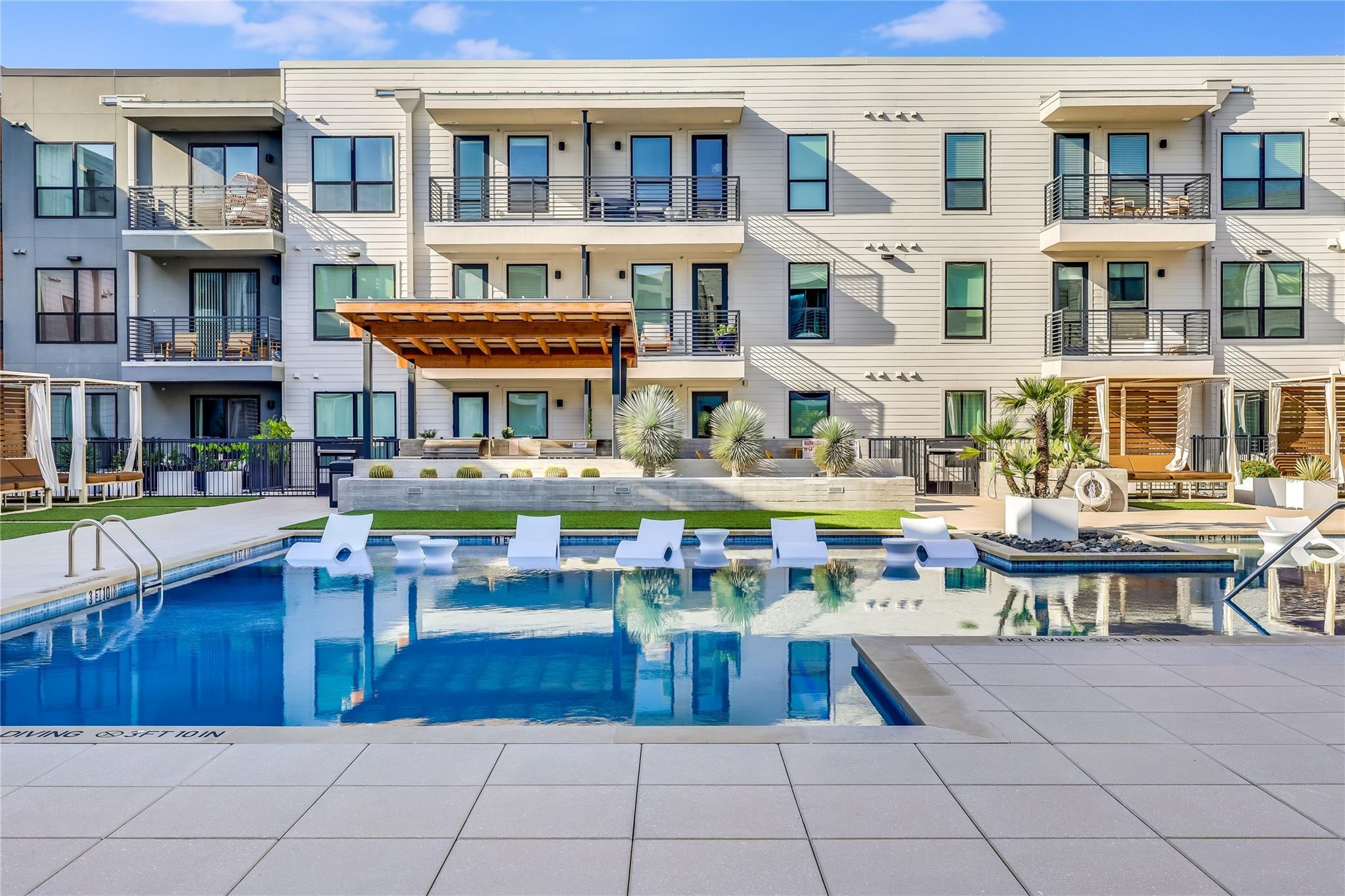 An inviting community pool with lounge chairs and