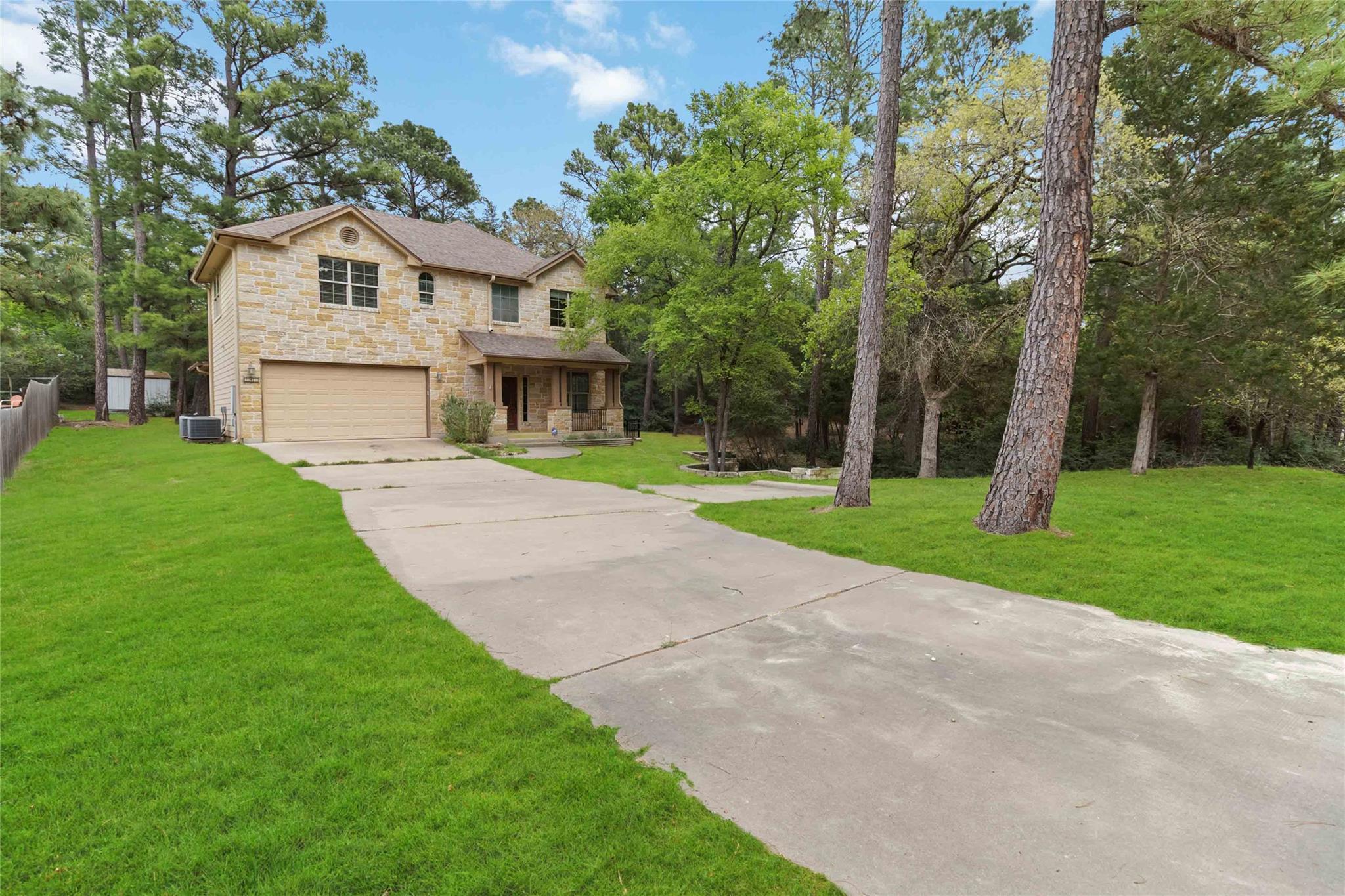 A spacious driveway leads to this charming stone-