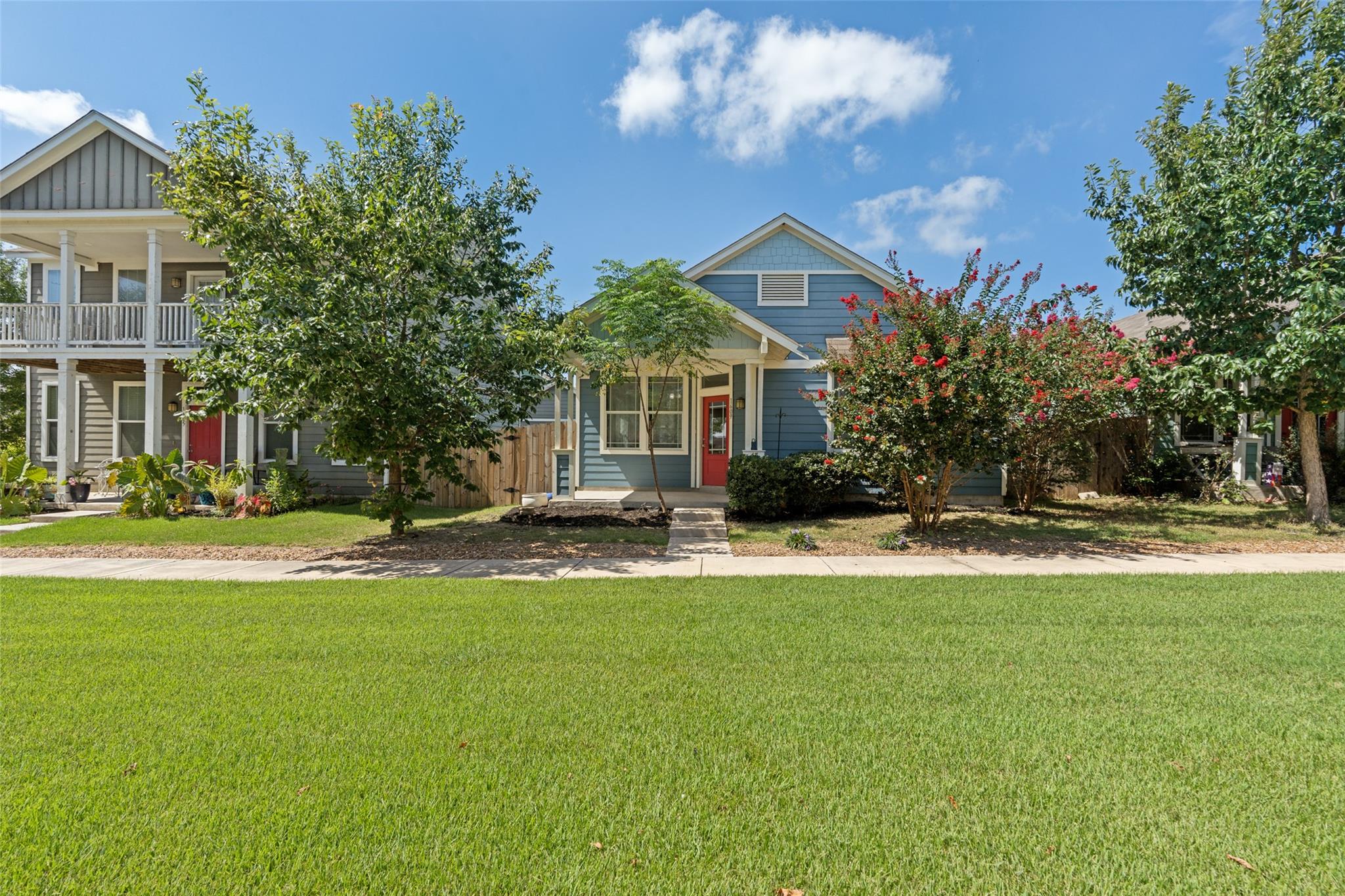 A charming blue residence with a bright red door 