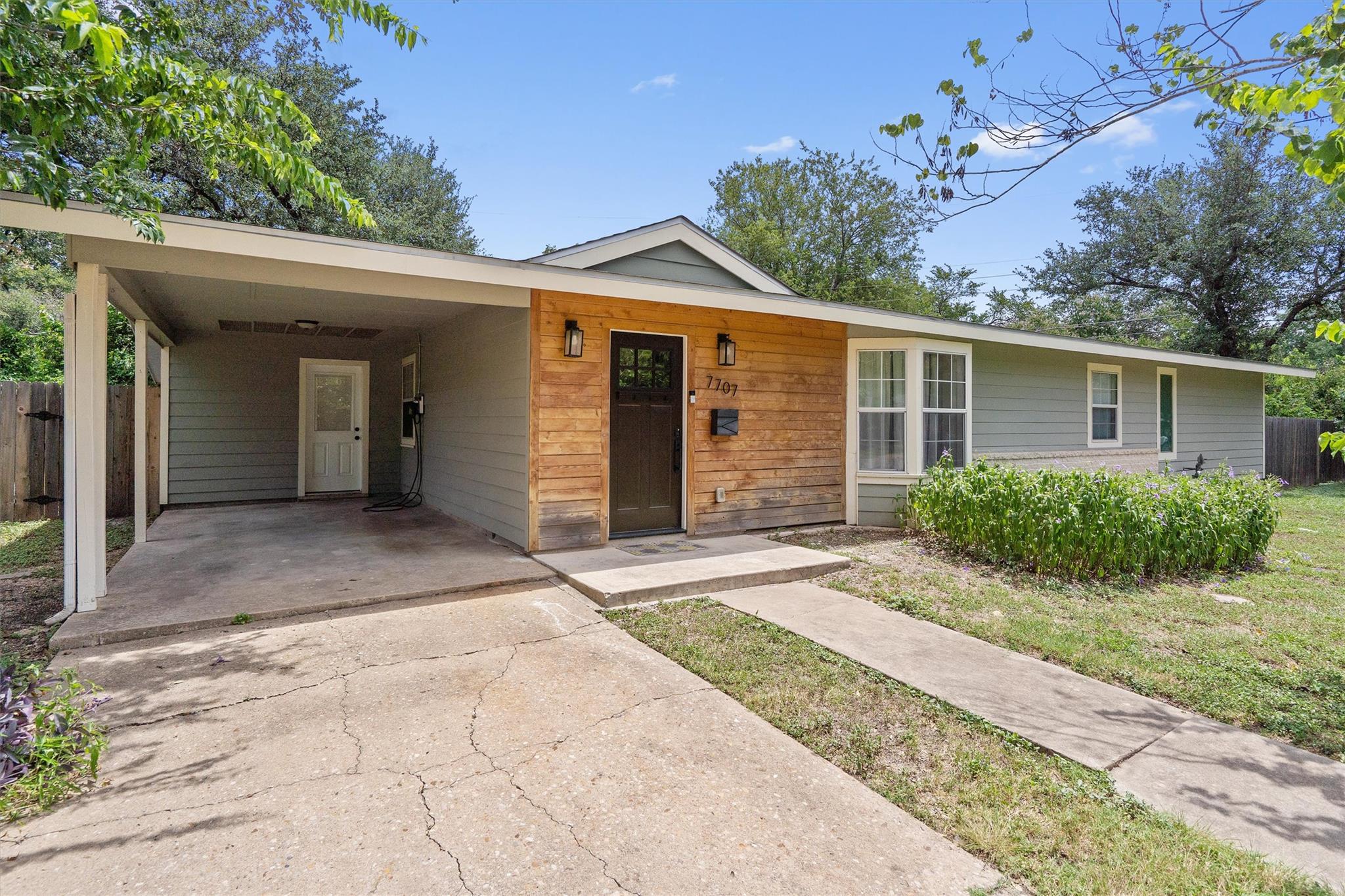 A welcoming facade with a covered carport and a b