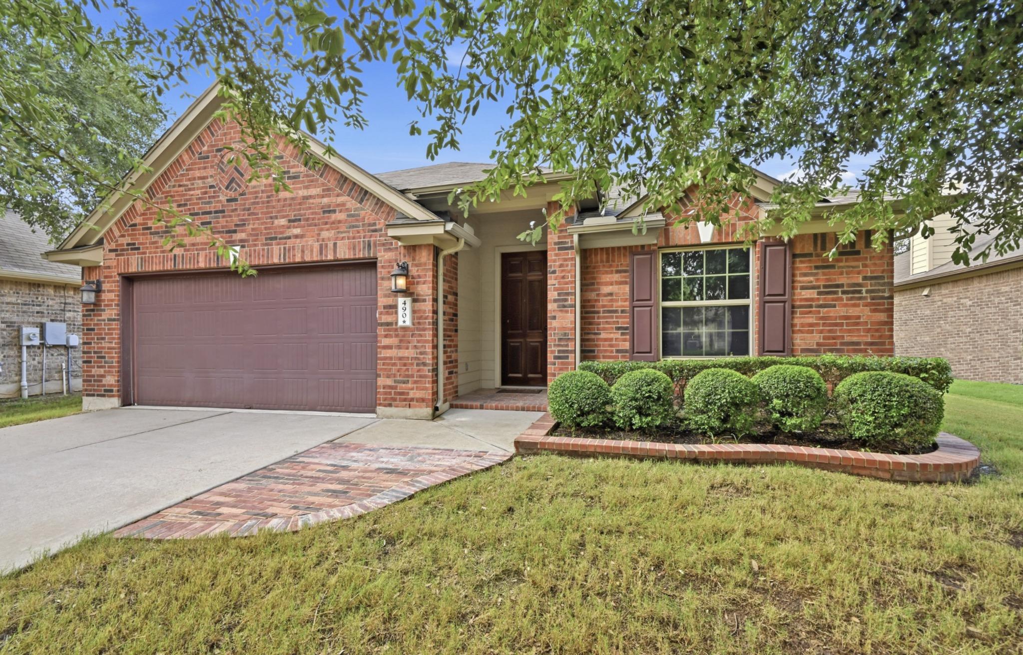 Brick facade with well-maintained landscaping enh