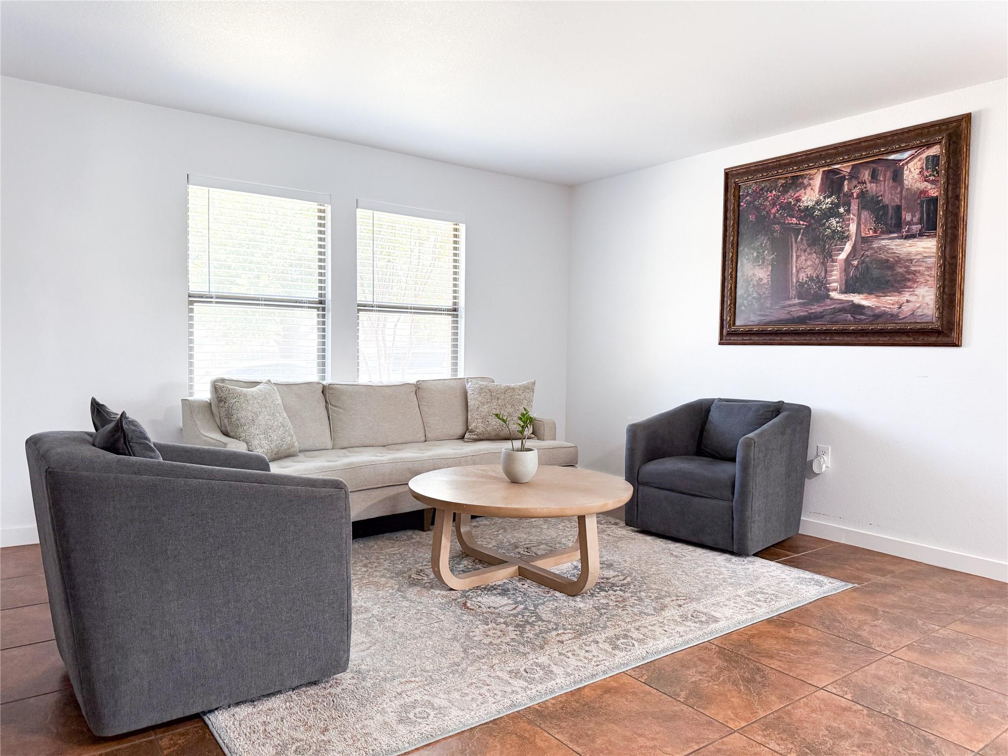 A comfortable living room features tile flooring 
