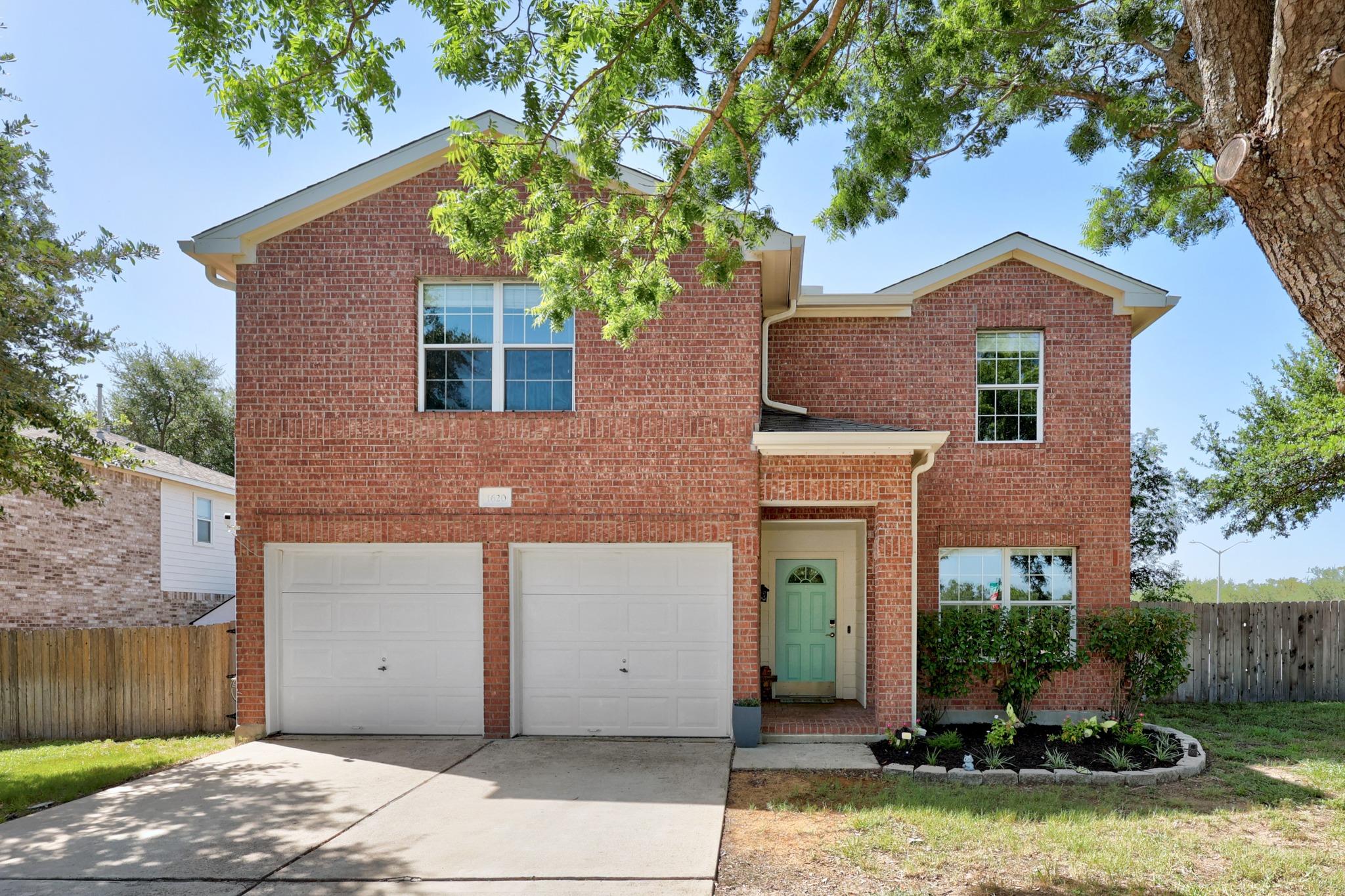 A classic brick exterior with a two-car garage, w