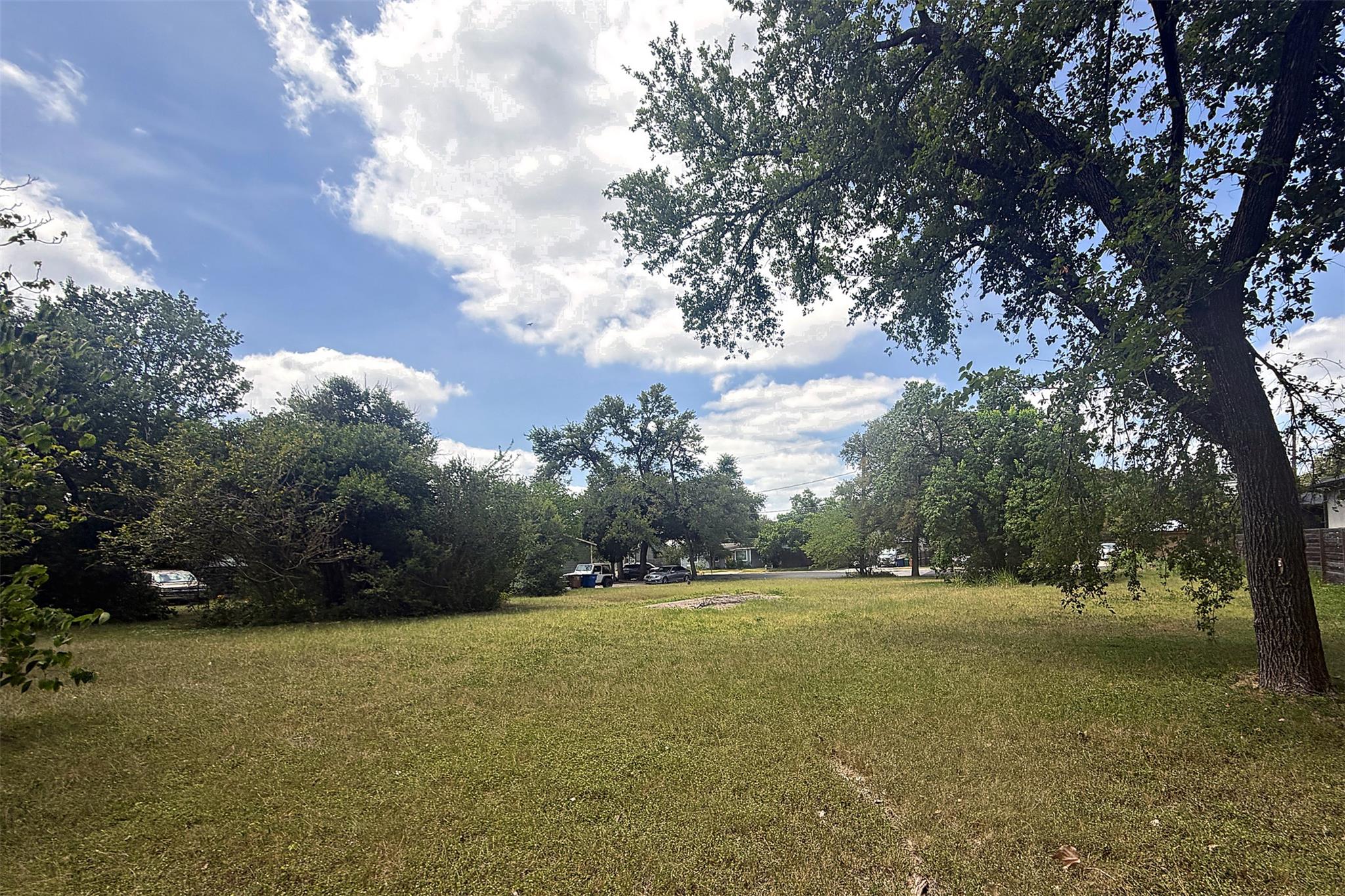 A spacious, verdant lot awaits your vision, surro