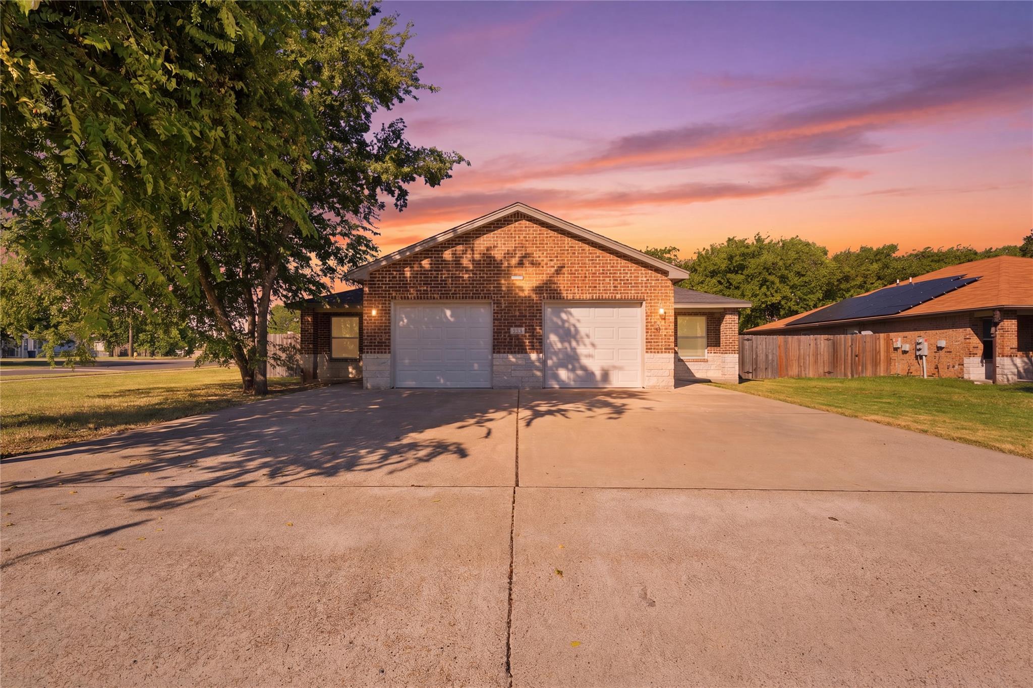 Brick facade with dual garage doors offers a welc