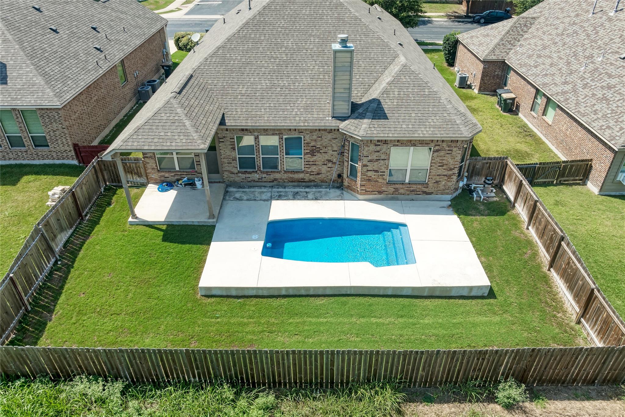 A private backyard oasis features a glistening po