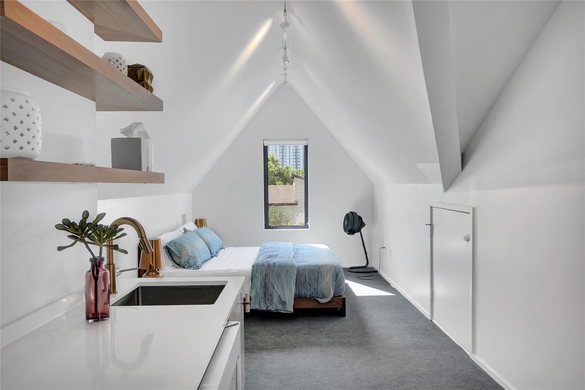 An attic bedroom with a sloped ceiling features a