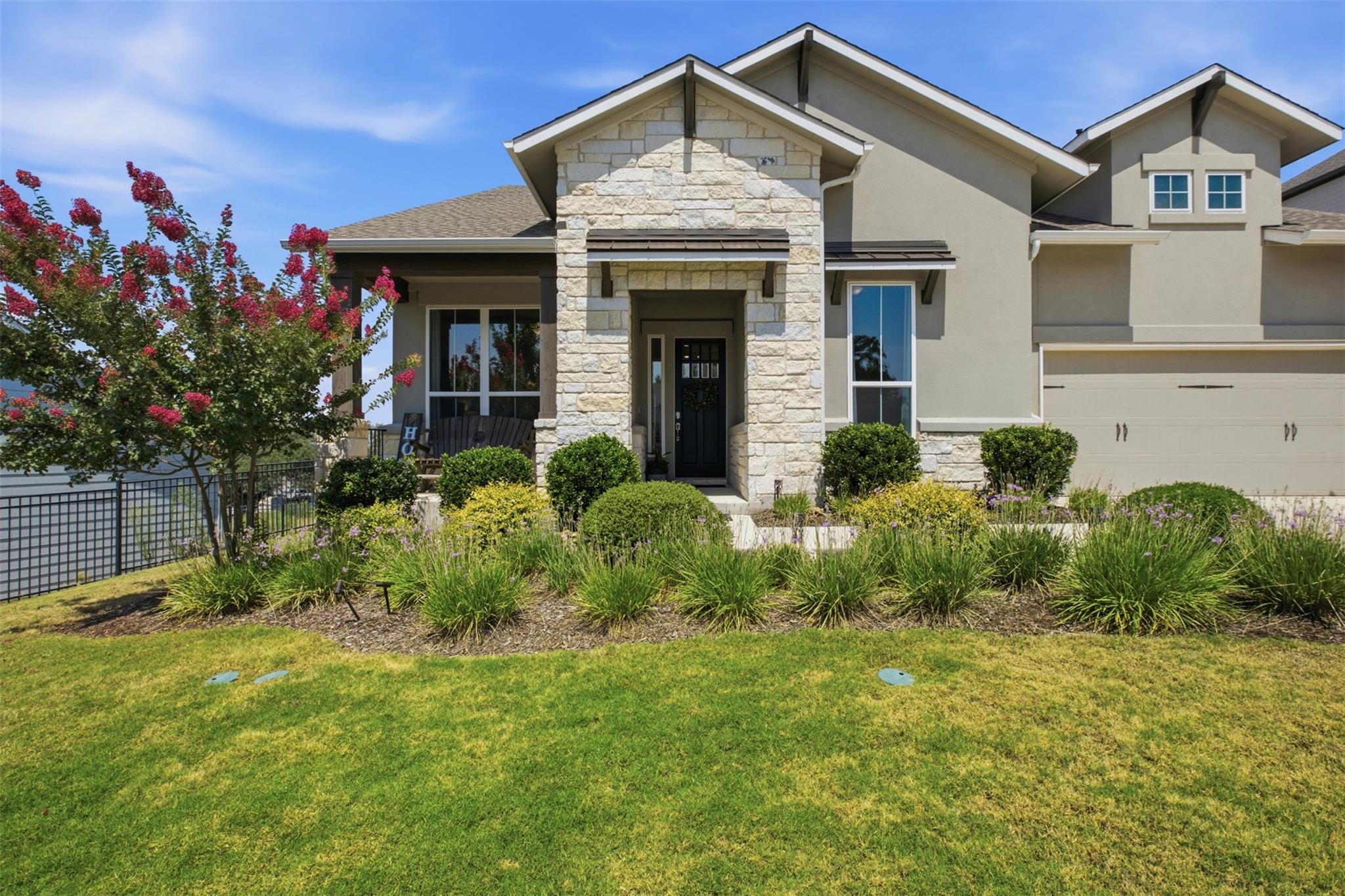 A welcoming stone and stucco facade complements t