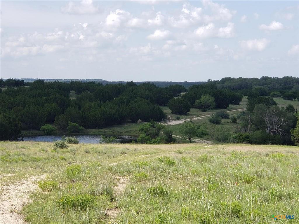 A tranquil pond nestles among rolling hills and v