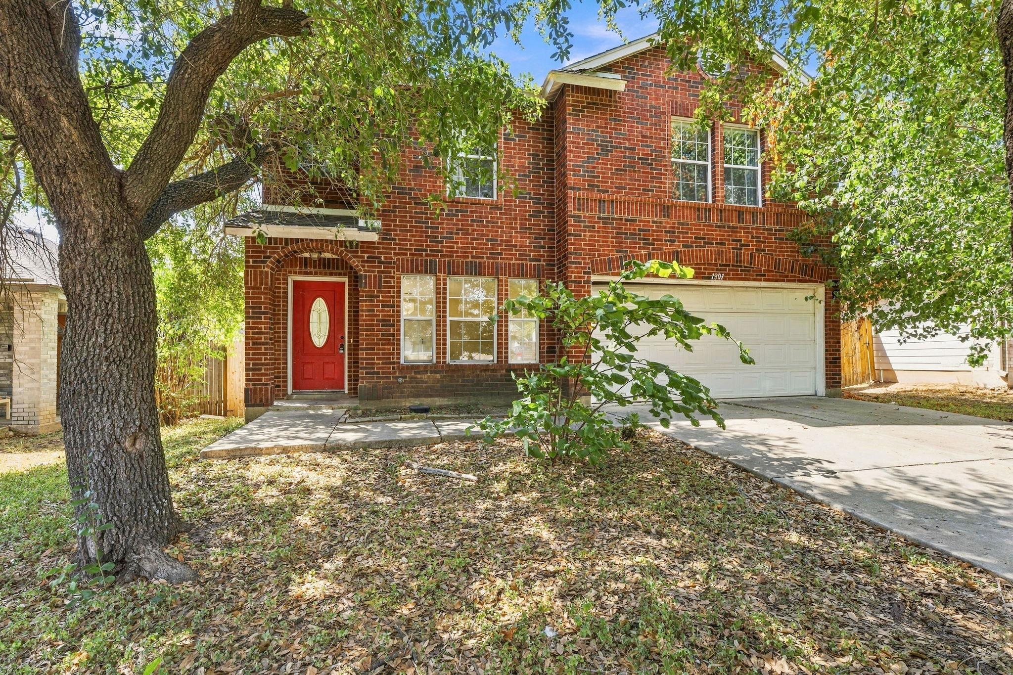 Mature shade trees frame a classic brick exterior