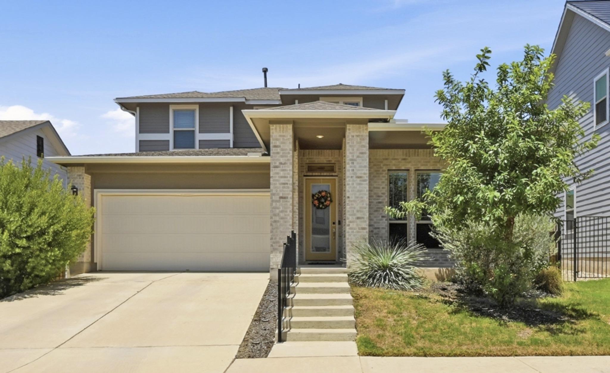 A welcoming facade showcases brick accents, a two