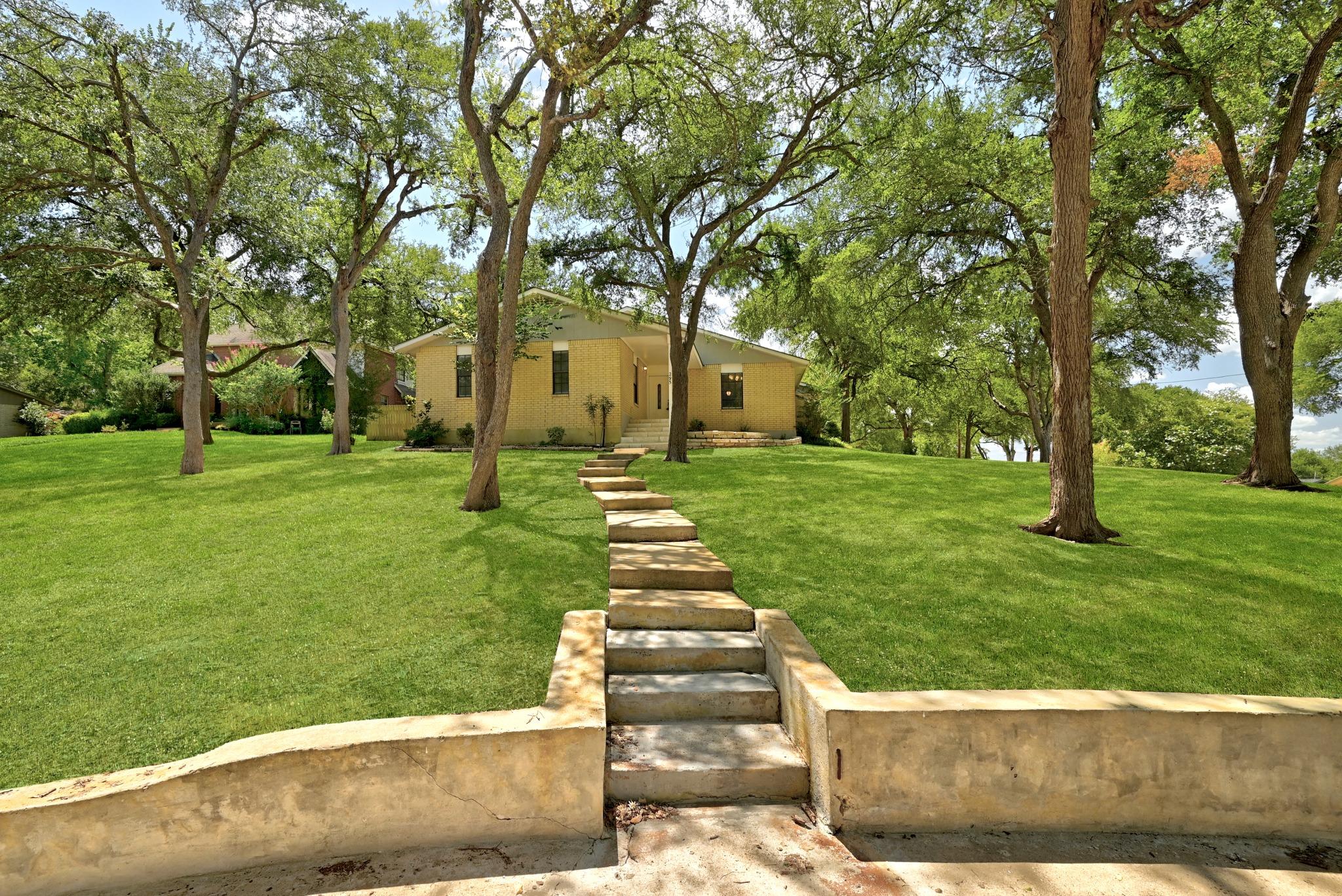 A graceful stone pathway leads through a verdant 
