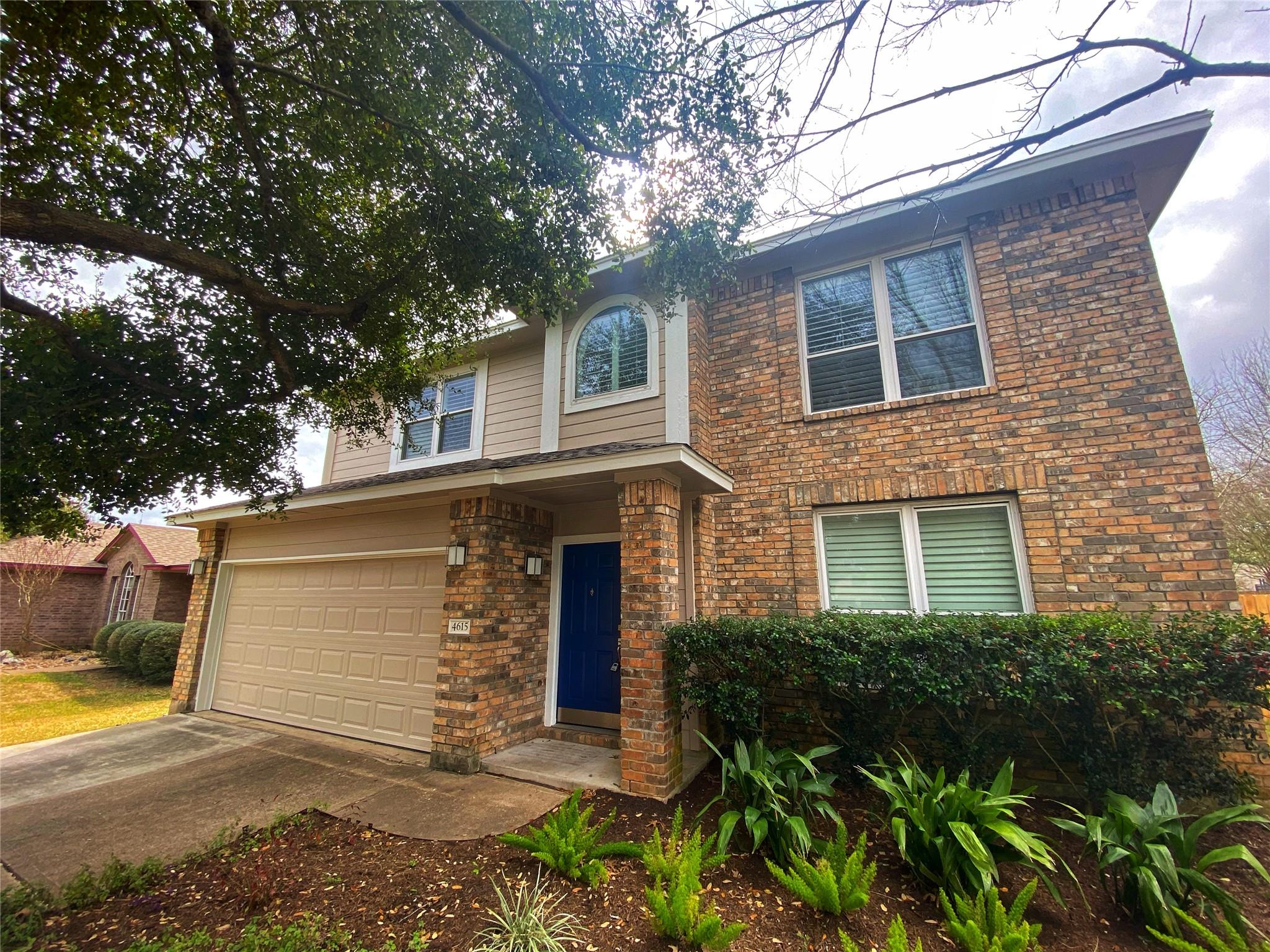 A classic brick and siding home presents a welcom