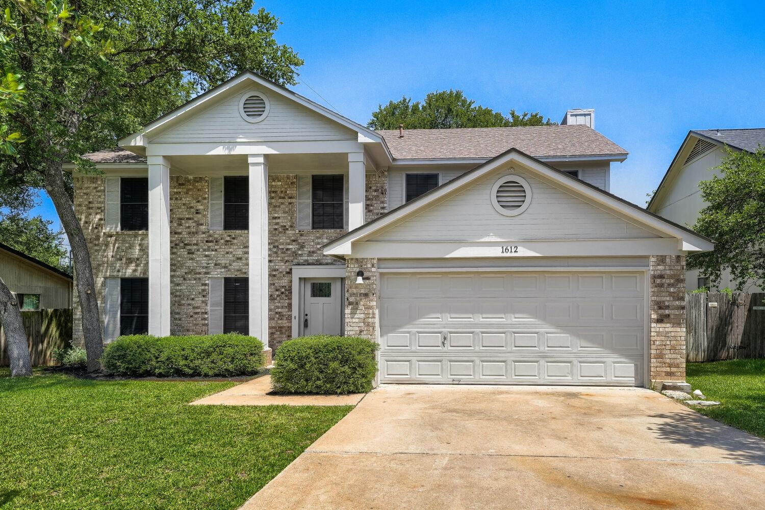 A classic brick-front home with prominent white c