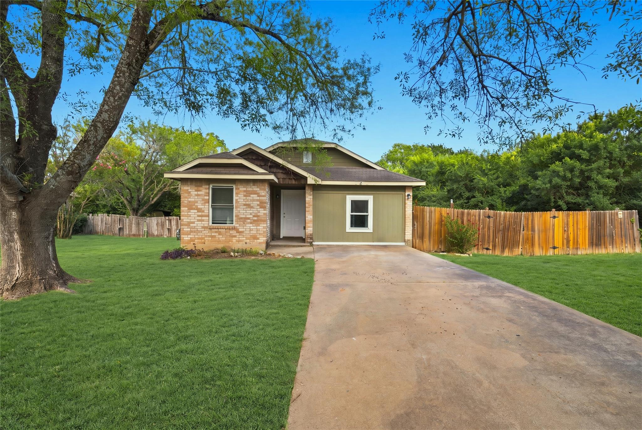 A well-maintained lawn and sturdy wooden fence fr