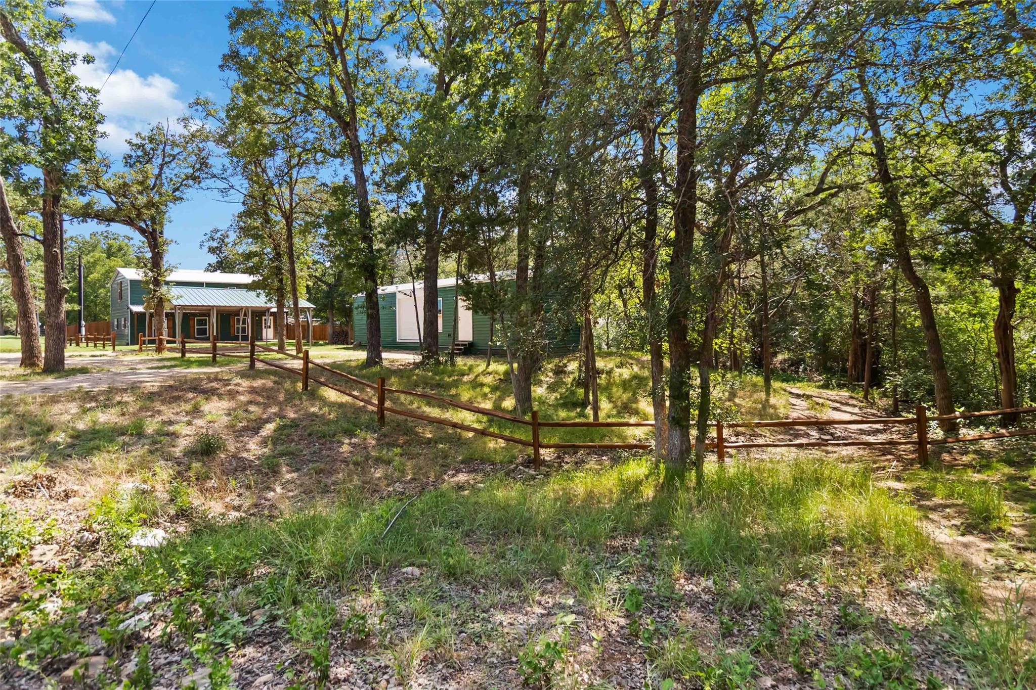 A rustic split-rail fence meanders through a wood
