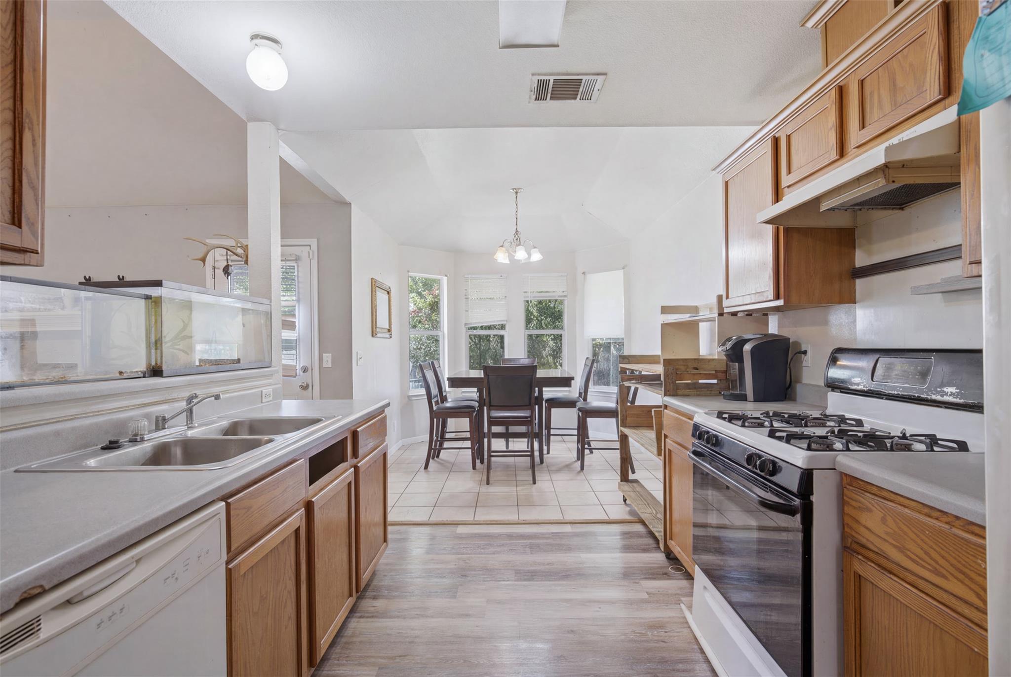 A well-lit kitchen with wood cabinetry opens to a