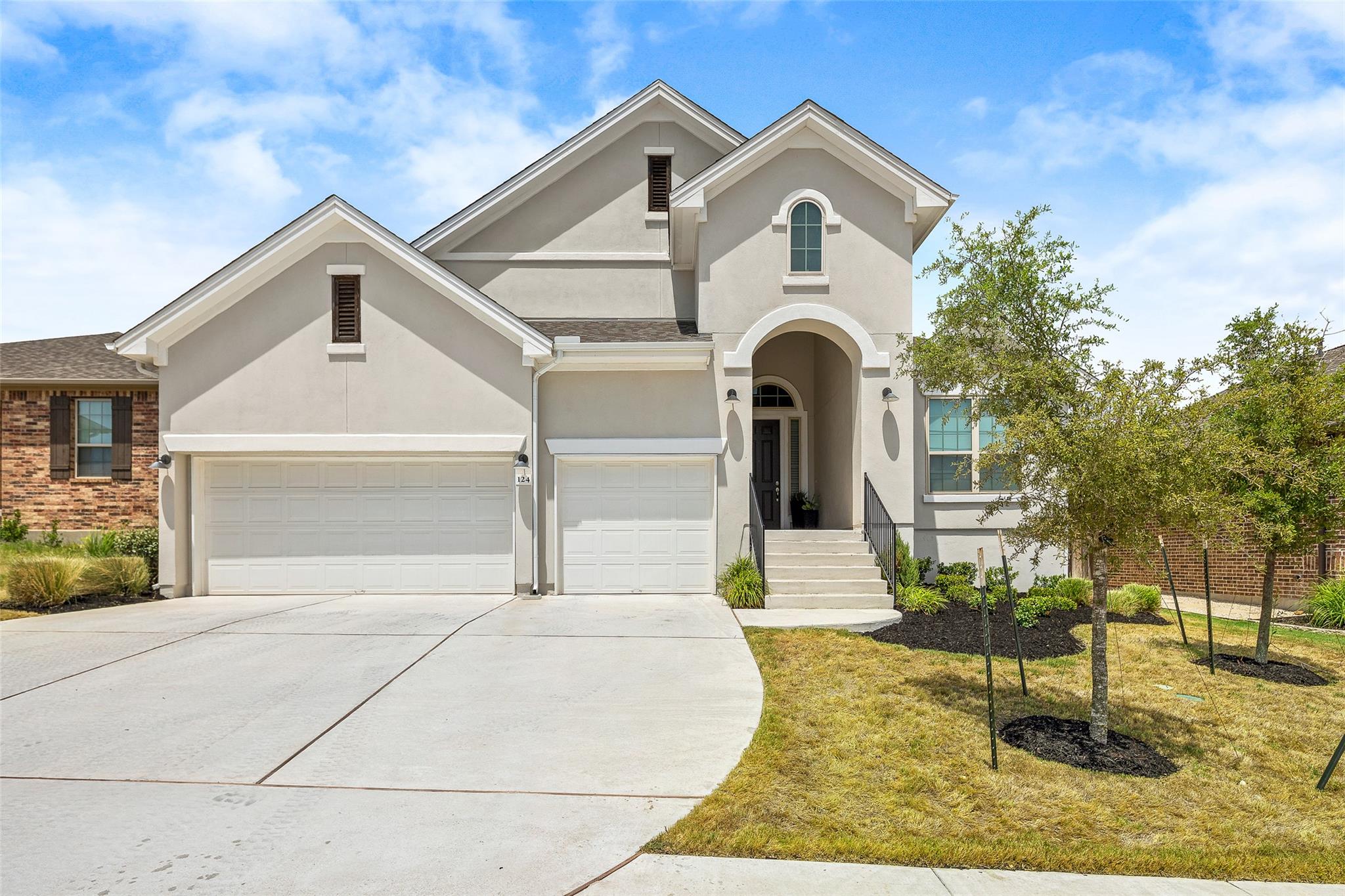 A graceful stucco facade with arched entry and du