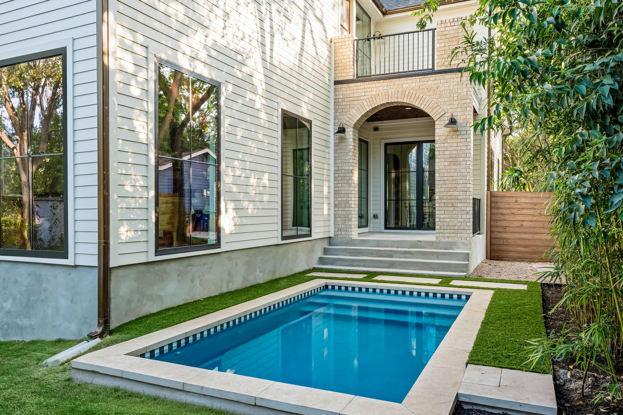 An inviting private pool and artificial turf are 
