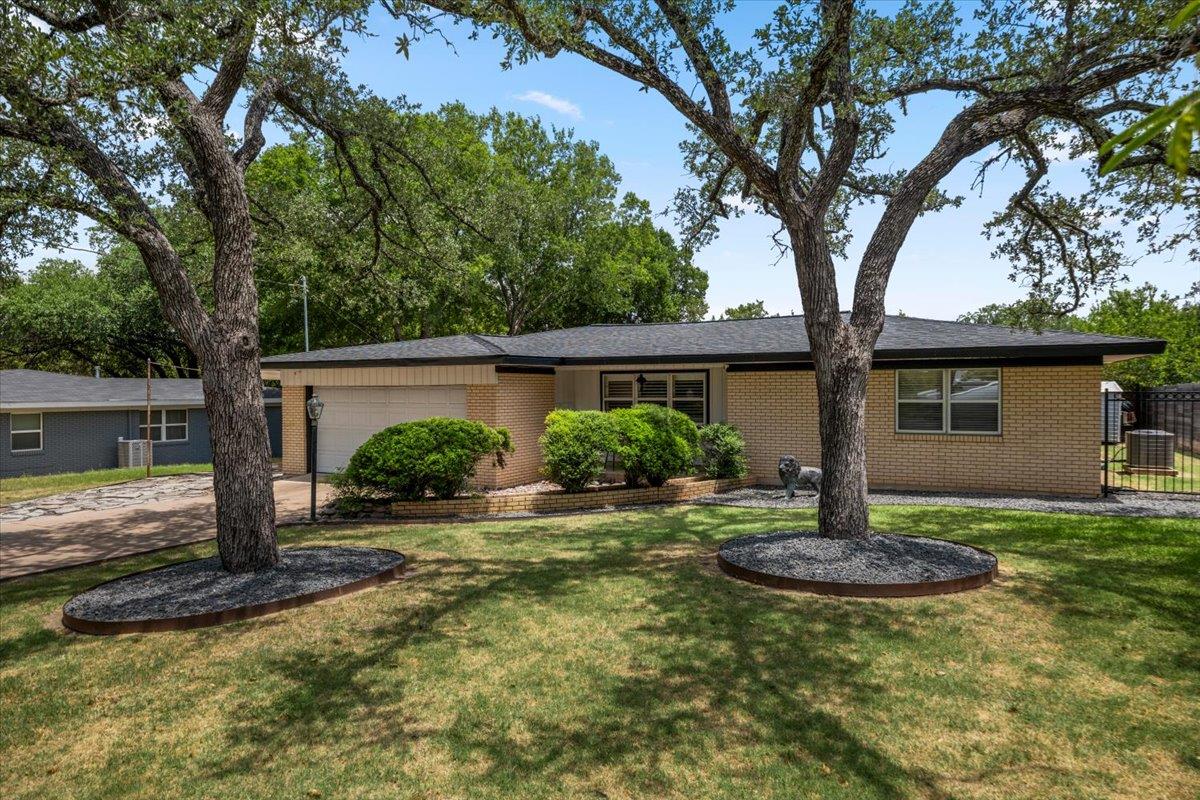Mature trees frame the neat front lawn of this ch