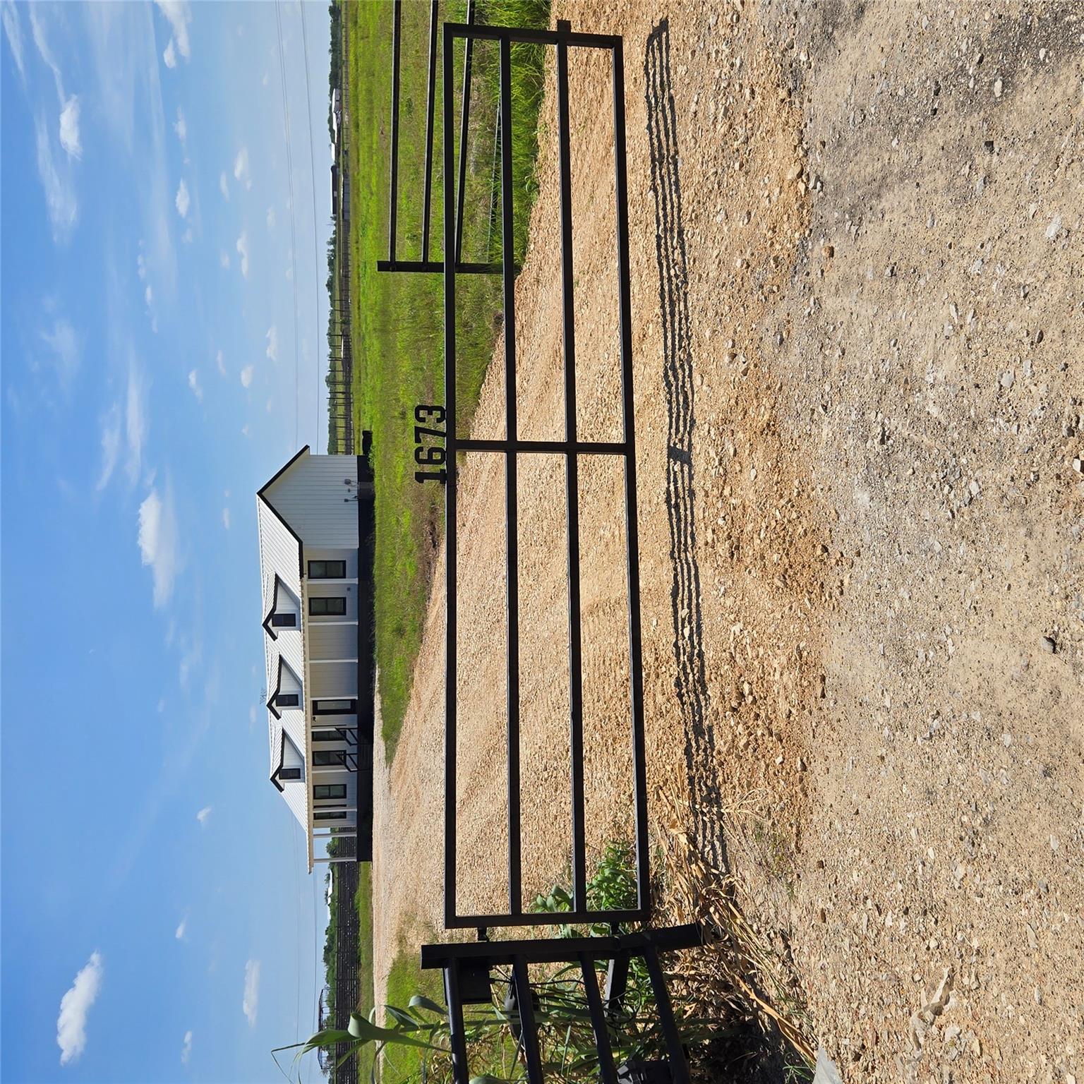 A private, gated driveway leads to a modern farmh