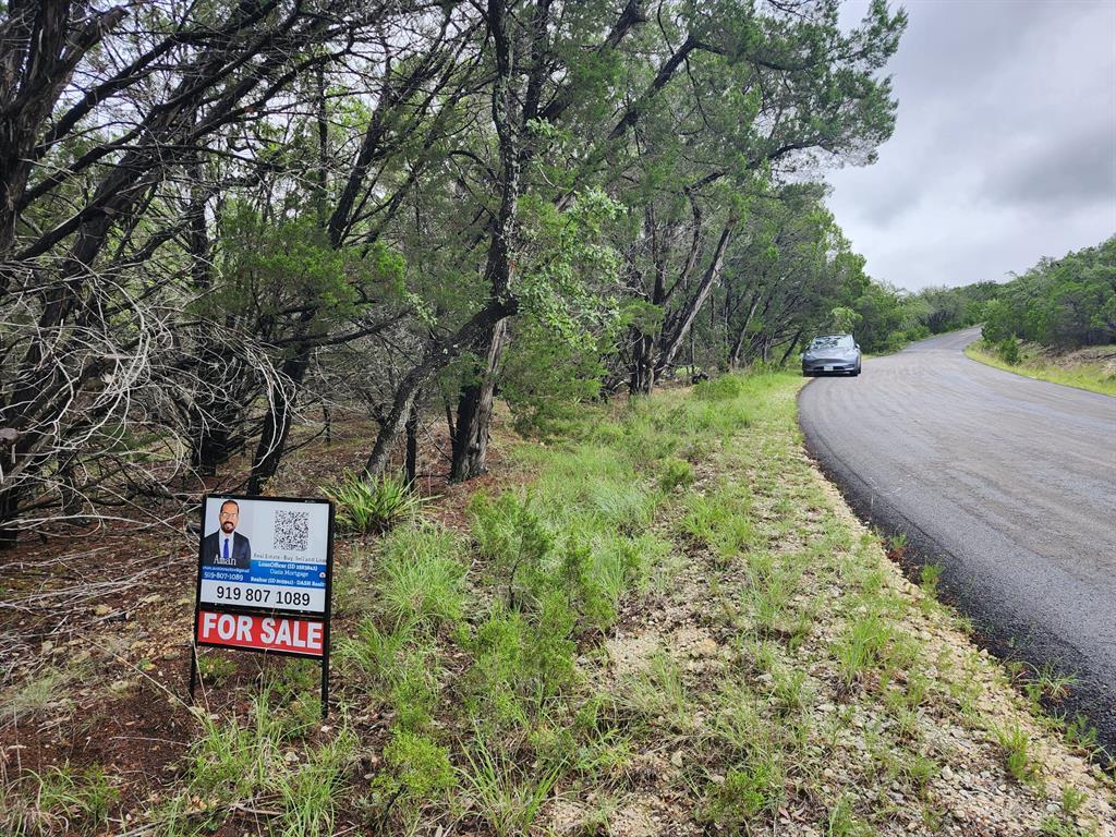 Mature trees line this private lot, offering a se