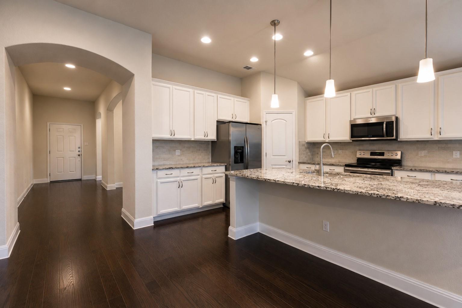 Modern kitchen with white cabinetry and dark wood