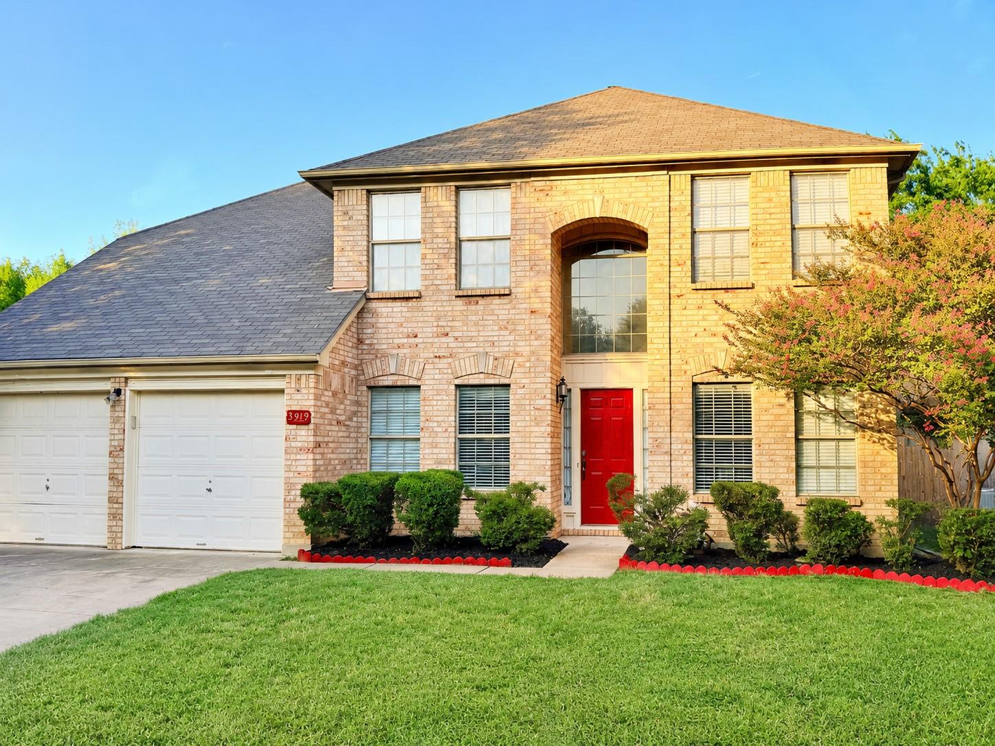 A well-maintained lawn and classic brick facade w