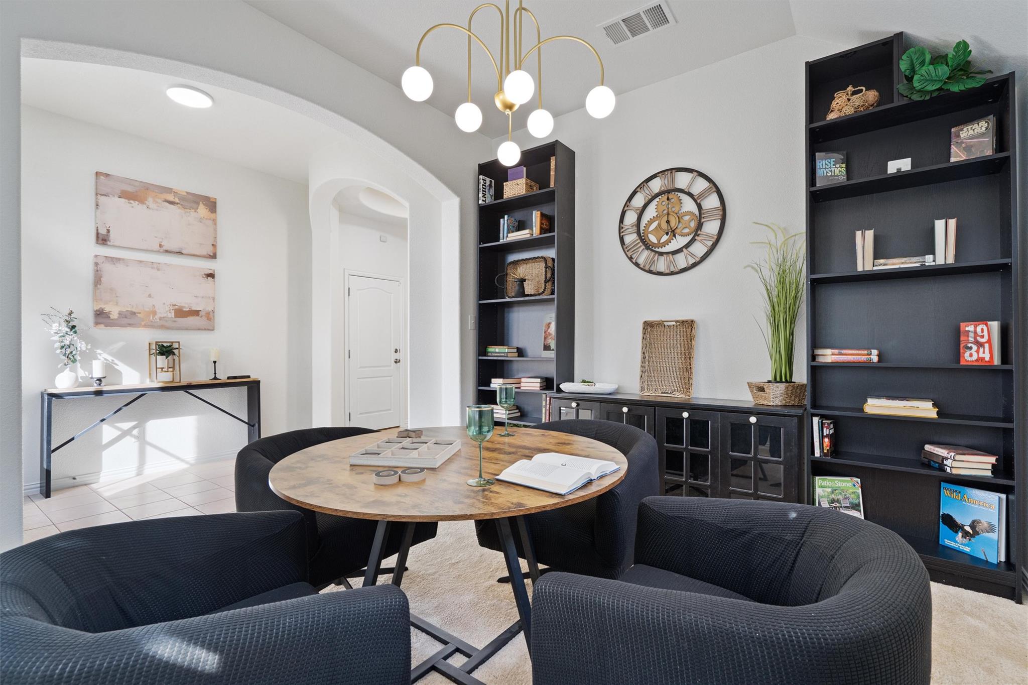 Recessed lighting and a stylish chandelier illumi