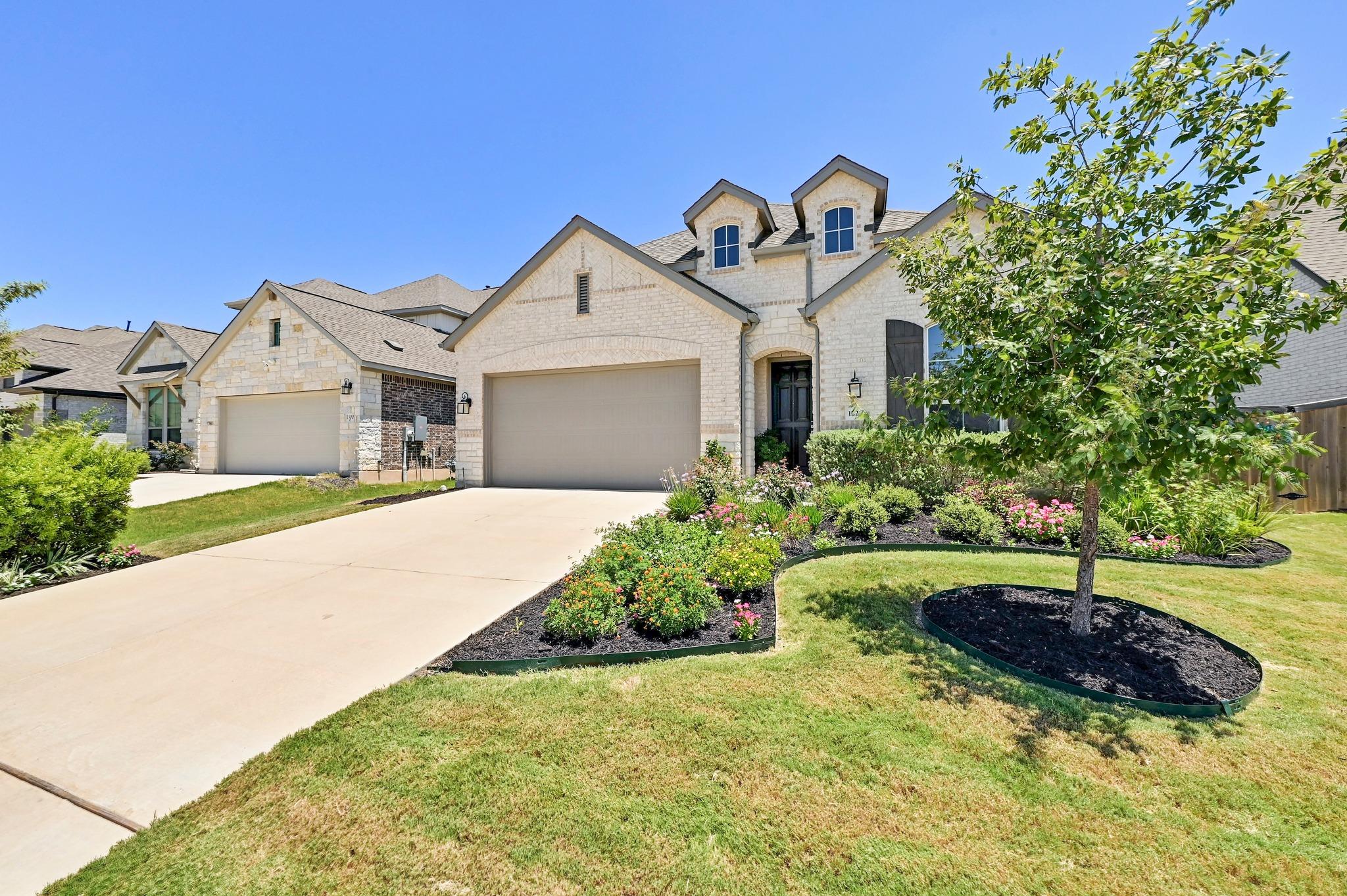 A graceful home with dormer windows and a manicur