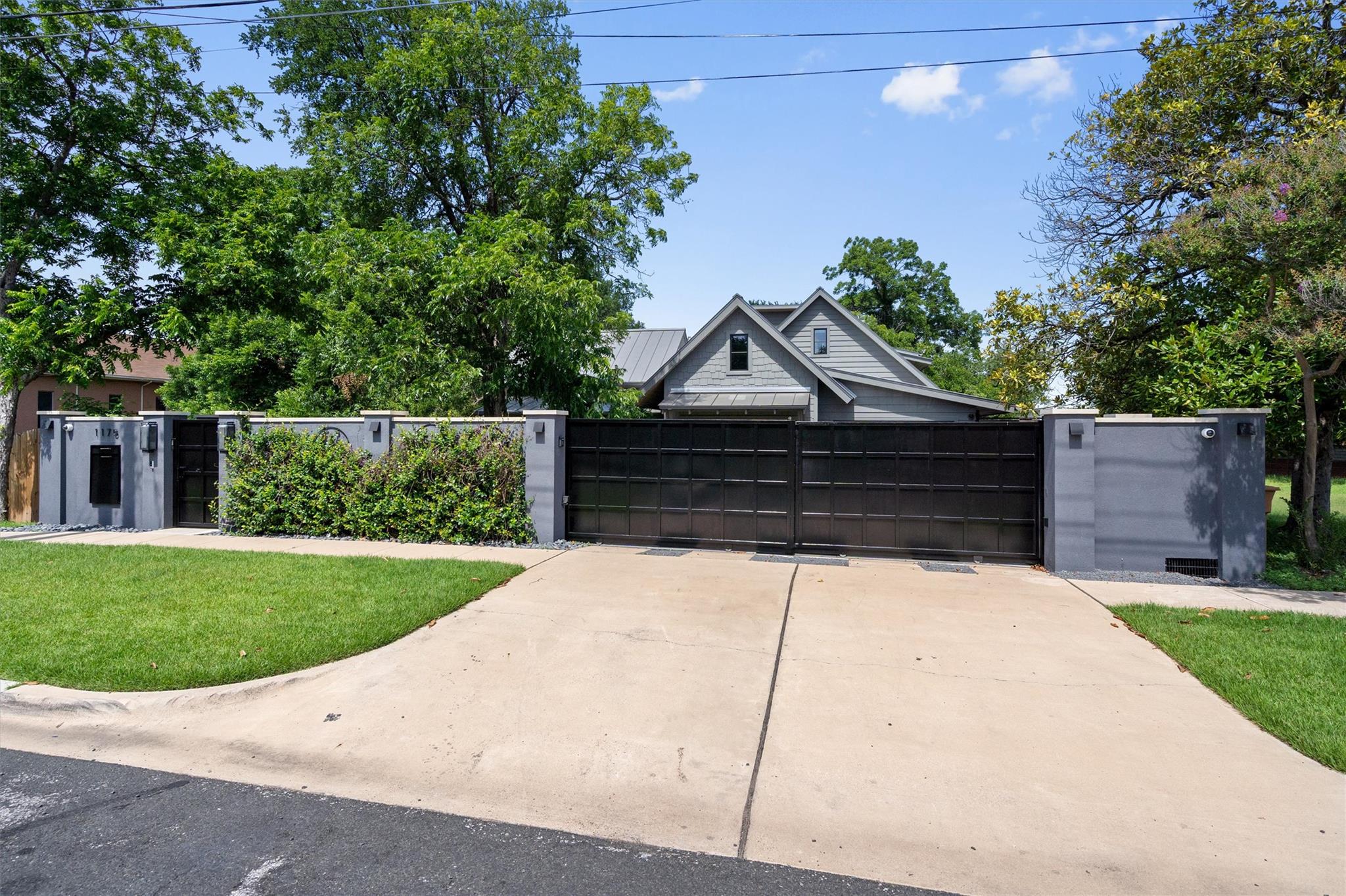 A private, gated driveway leads to a modern resid