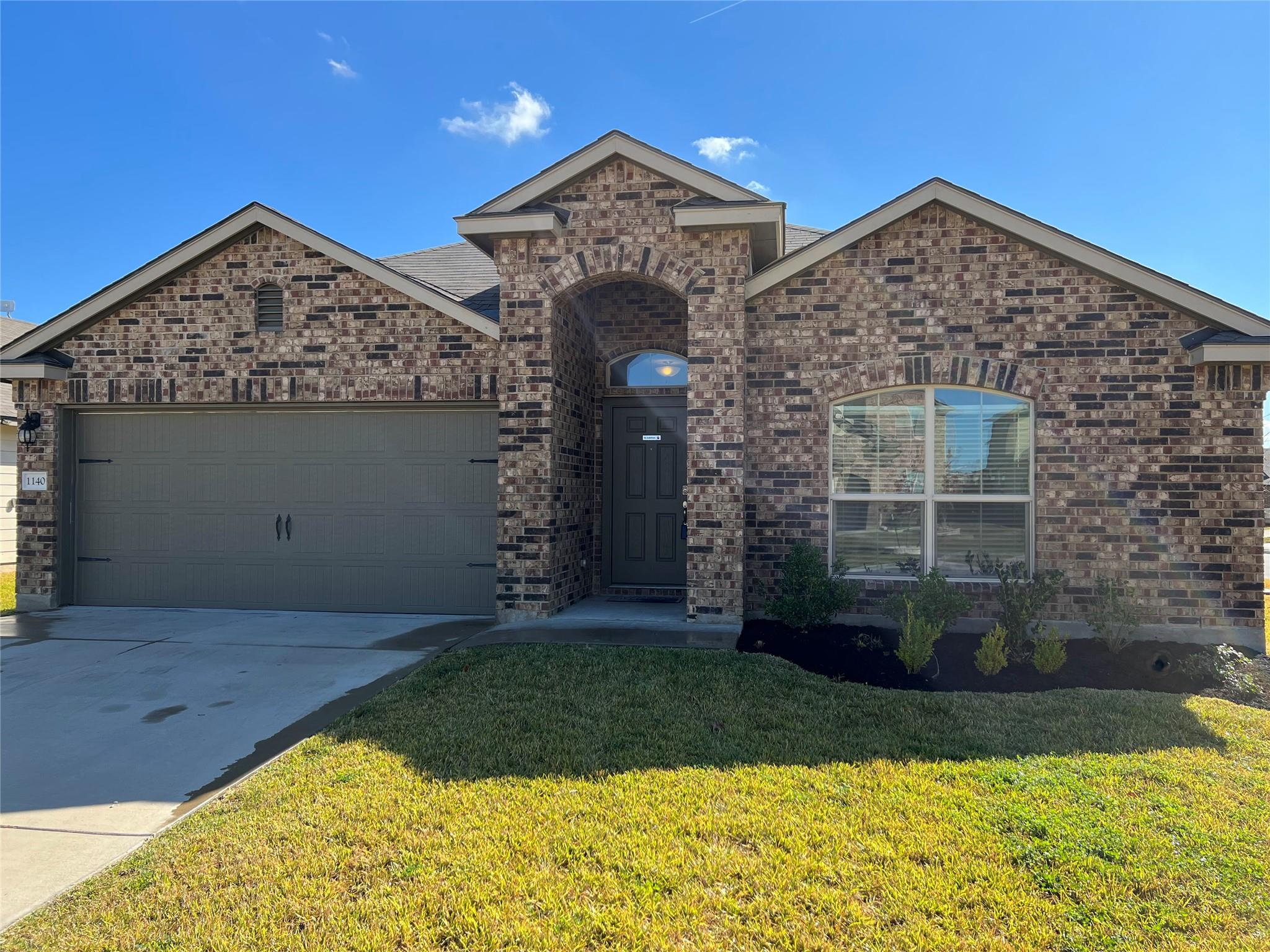A classic brick facade welcomes you home with a w
