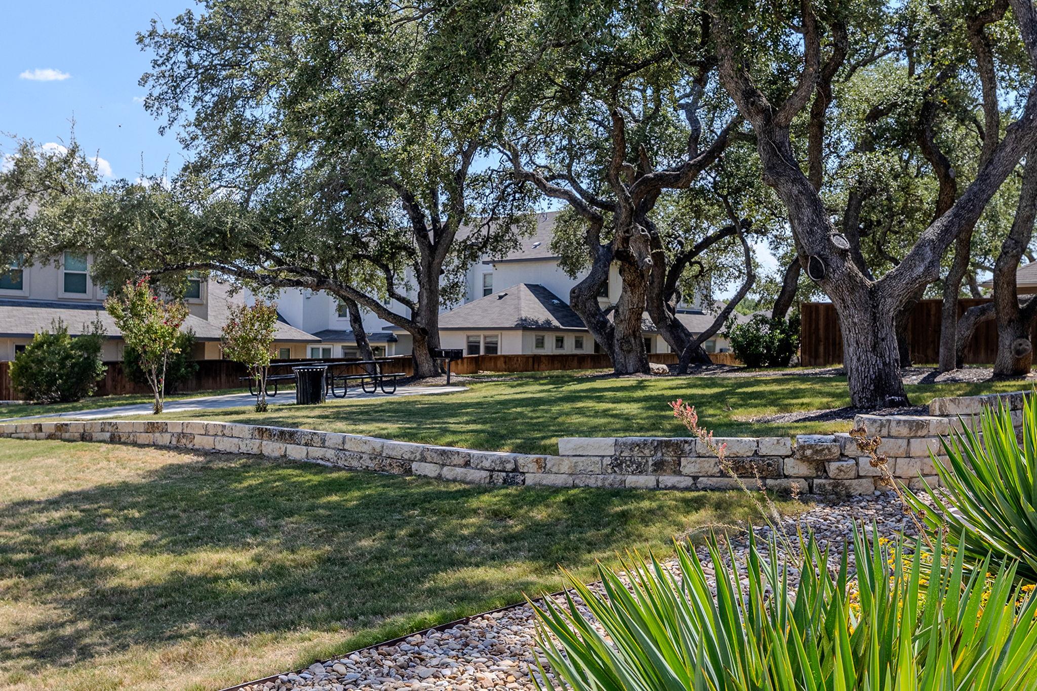 A stone retaining wall gracefully defines a lush 