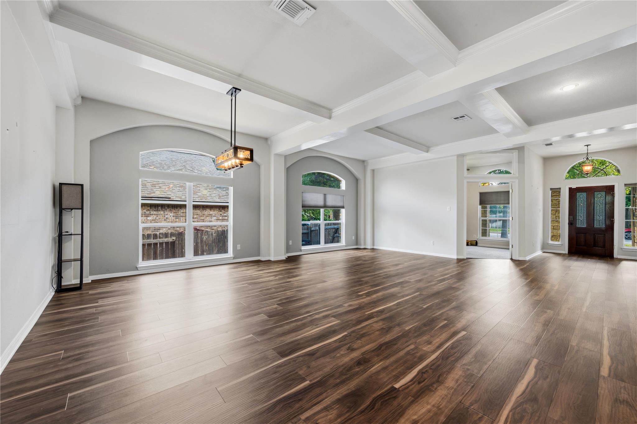 Rich hardwood floors complement the coffered ceil