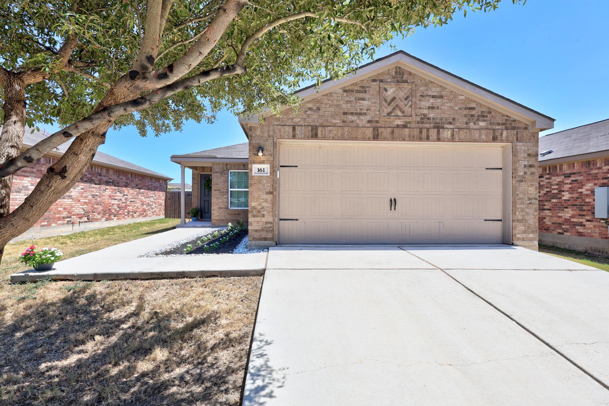 Classic brick accents and a tidy concrete drivewa