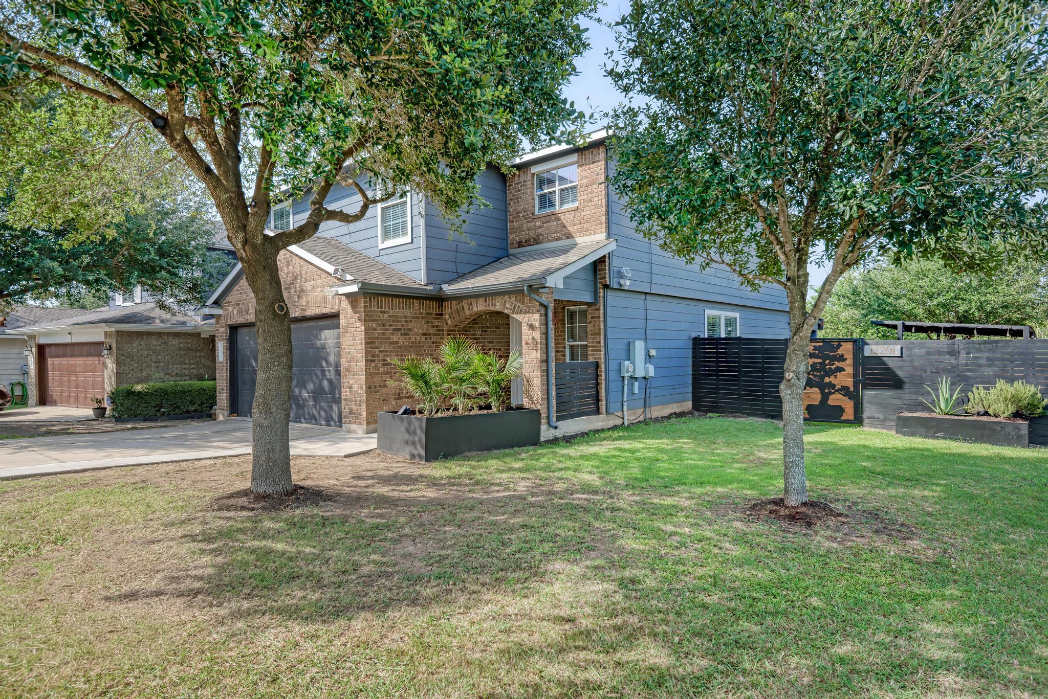 Mature trees frame the front lawn, complementing 