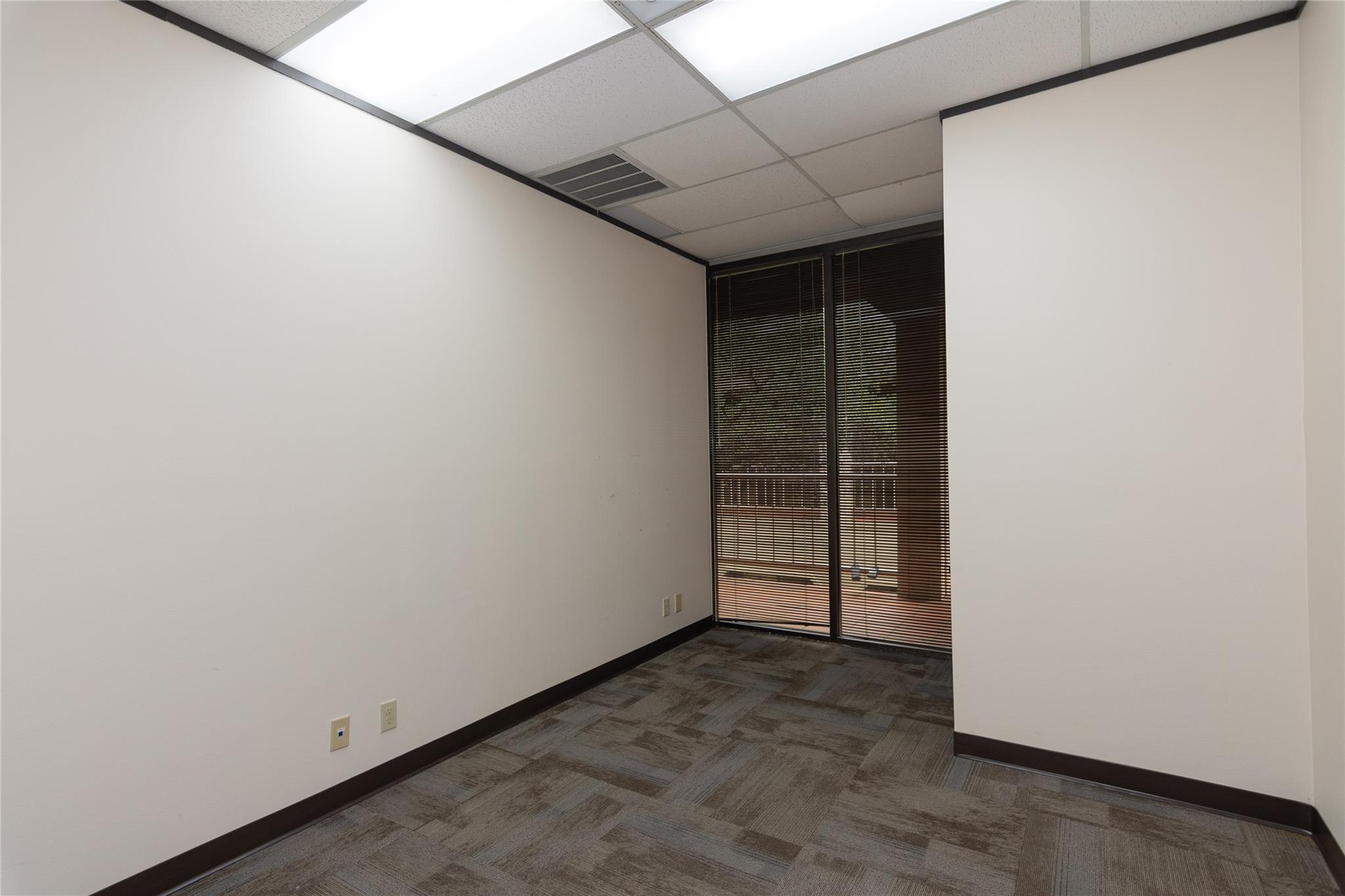 A well-lit room with large windows offers a flexi