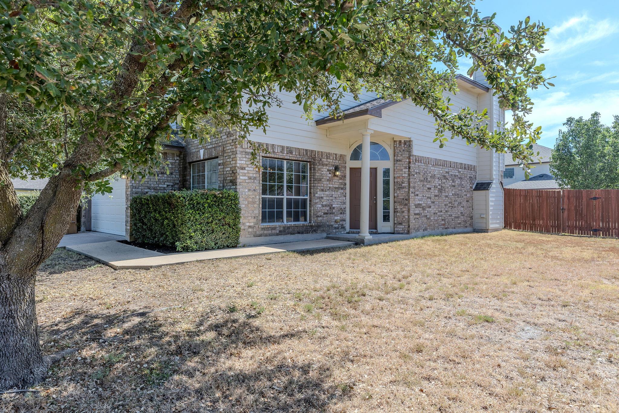 Mature trees shade a welcoming front walkway lead