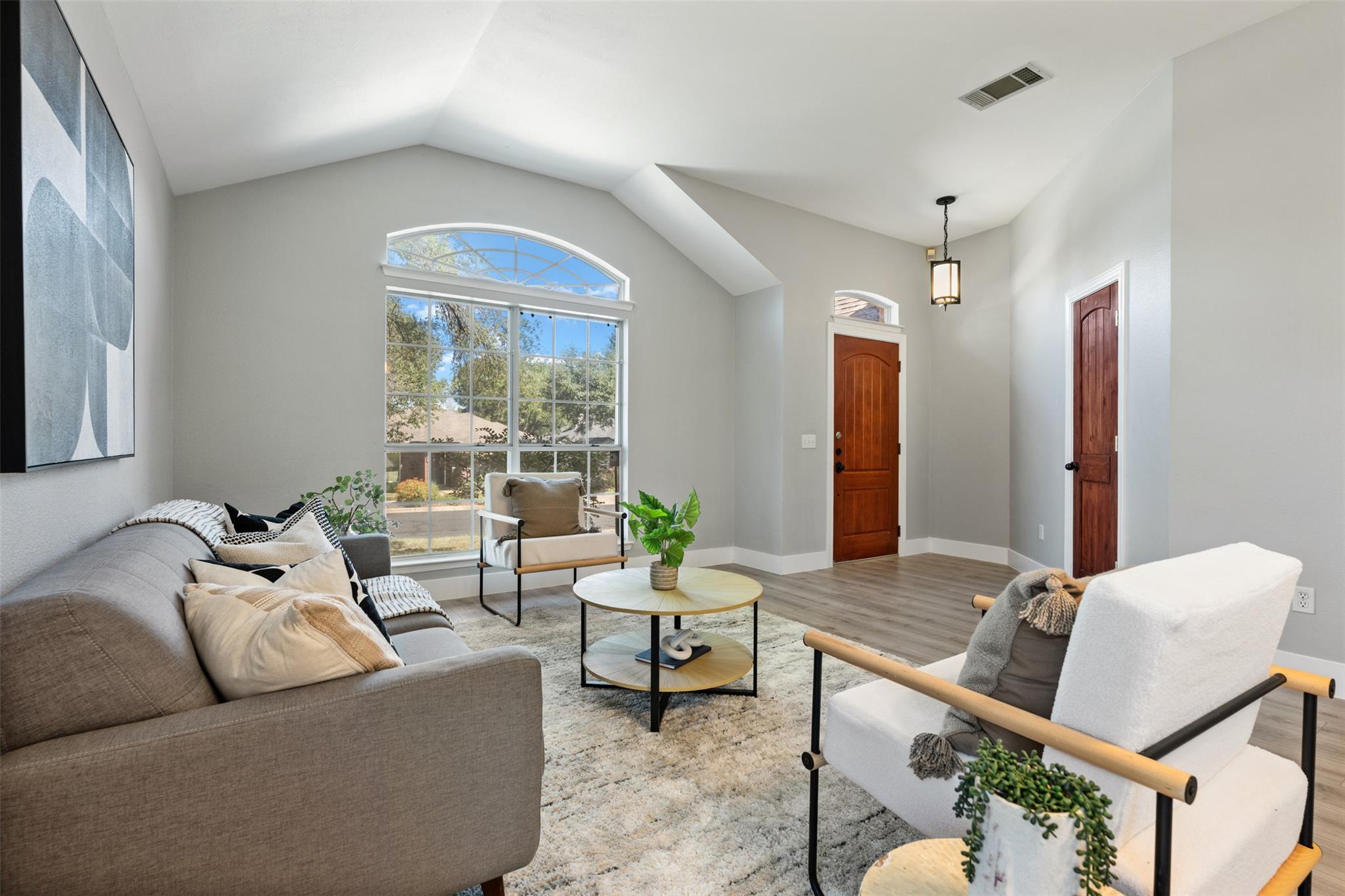 A vaulted ceiling living room features an arched 