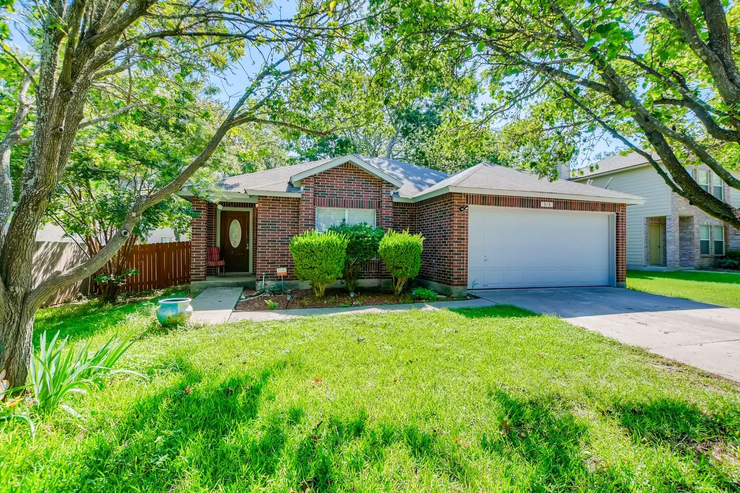 Mature trees shade this charming brick home with 