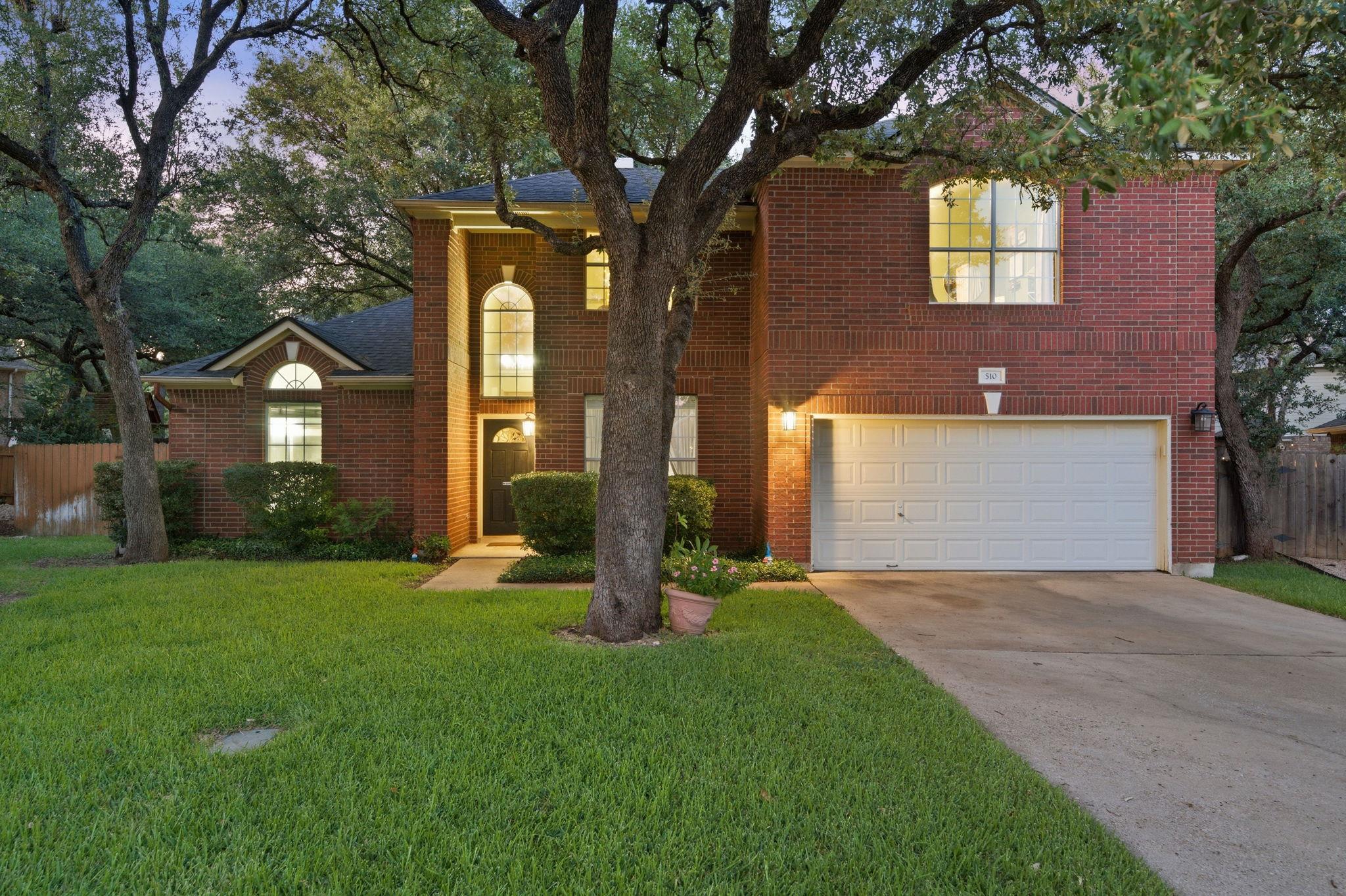 Mature trees frame this traditional brick residen