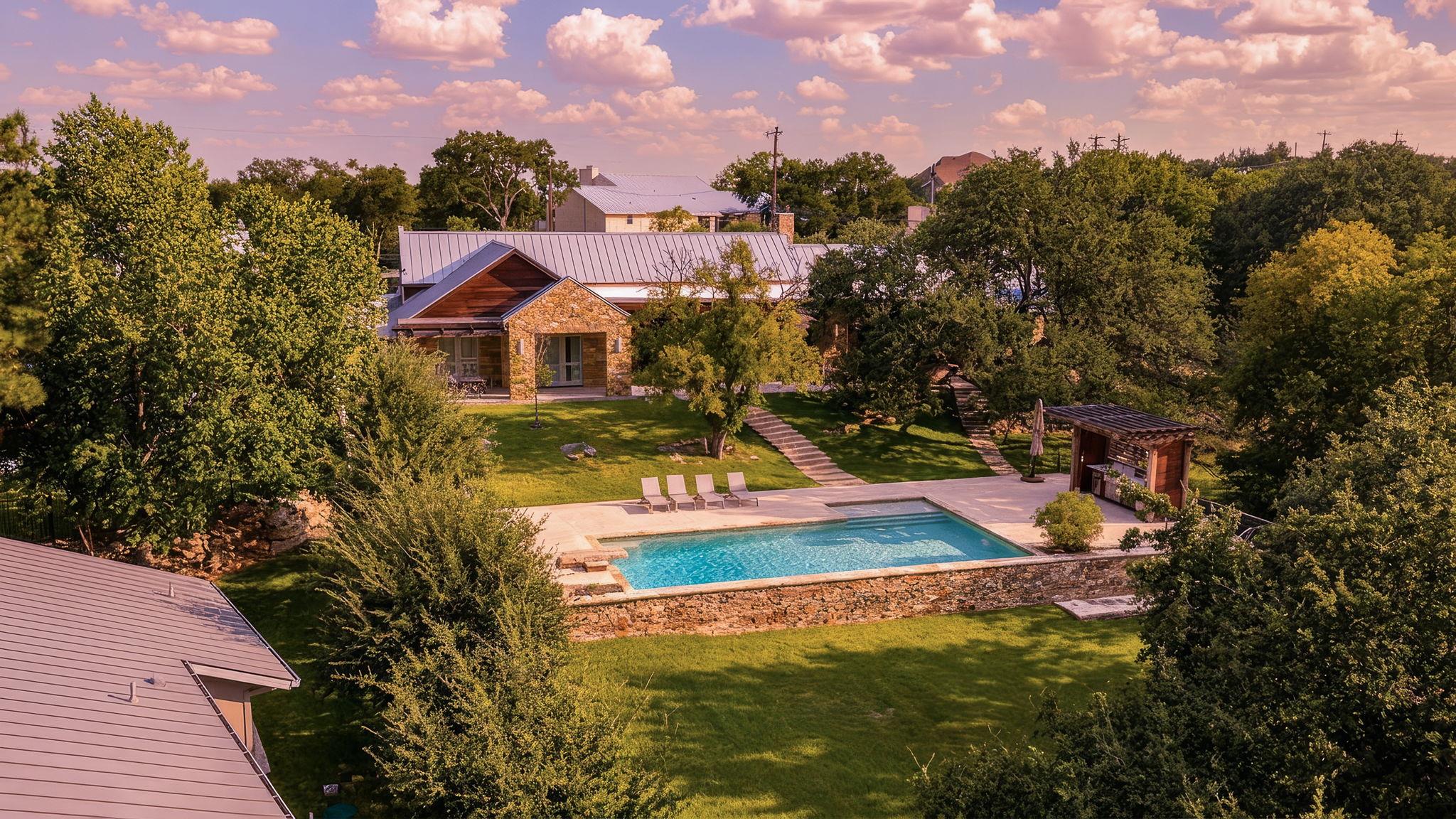 An inviting backyard oasis offers a serene pool, 