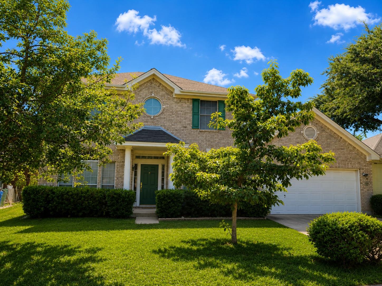 A classic brick facade welcomes with a tidy lawn 