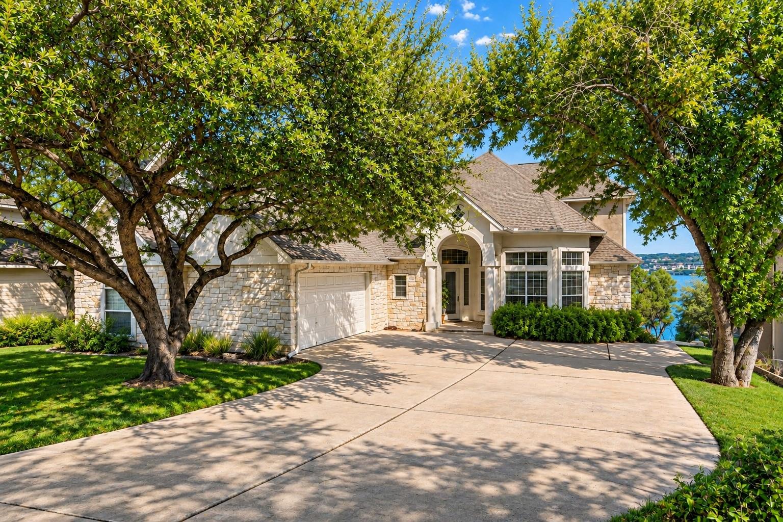 Mature trees frame a stone facade and spacious dr