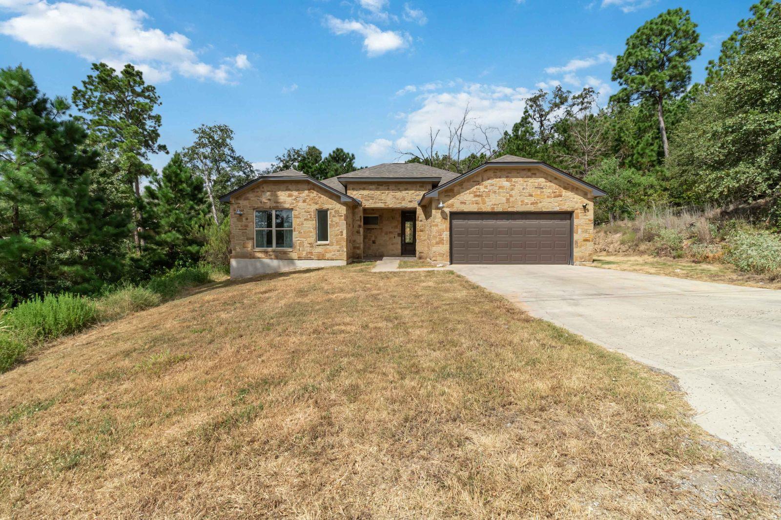 A welcoming stone facade home with an attached ga