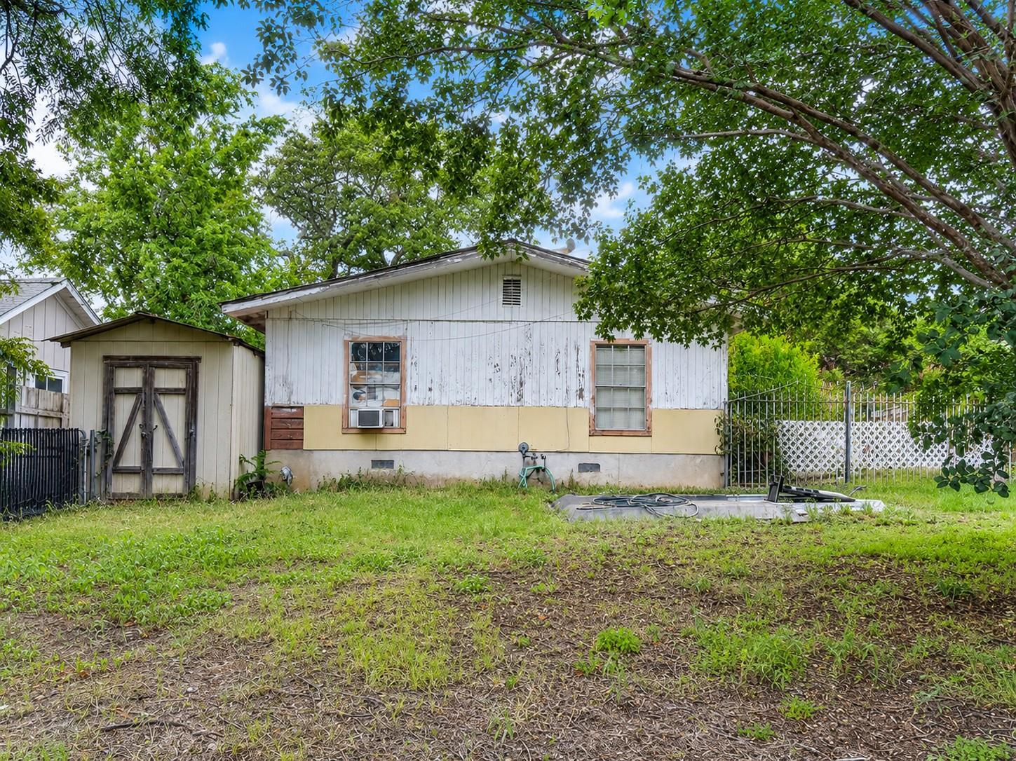 A well-treed yard frames this single-story struct