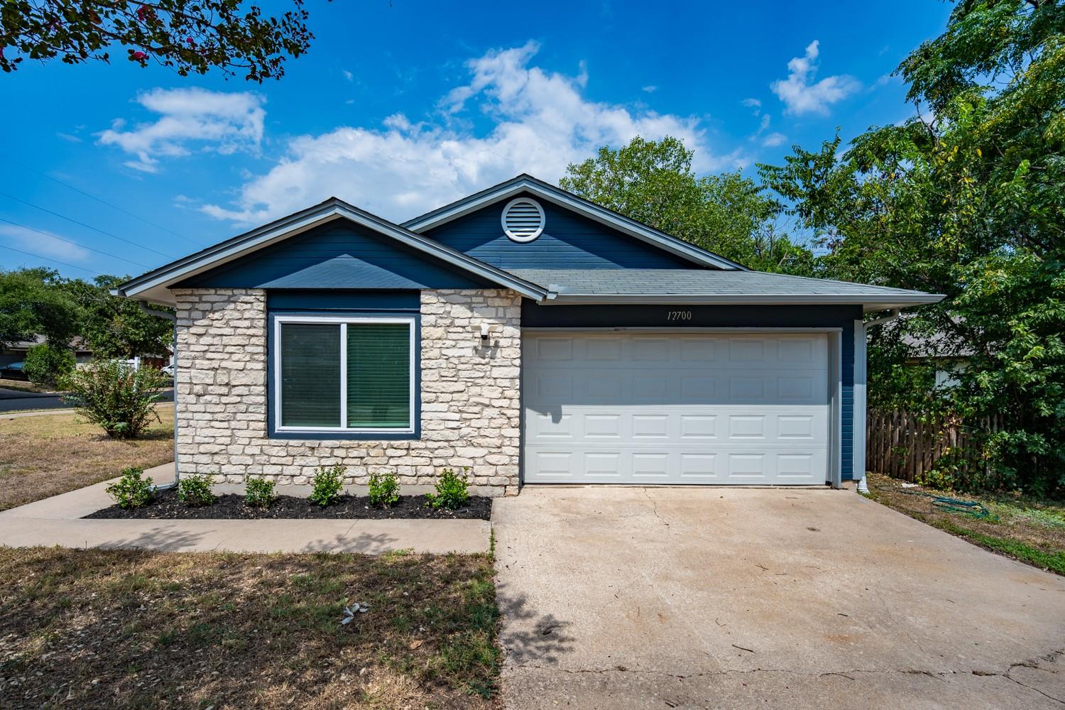 Textured stone veneer accents the exterior of thi