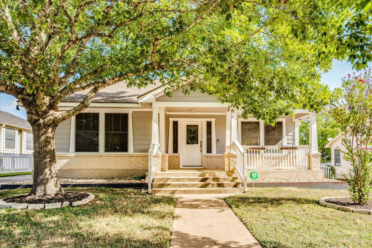 Mature shade trees frame a welcoming front porch 