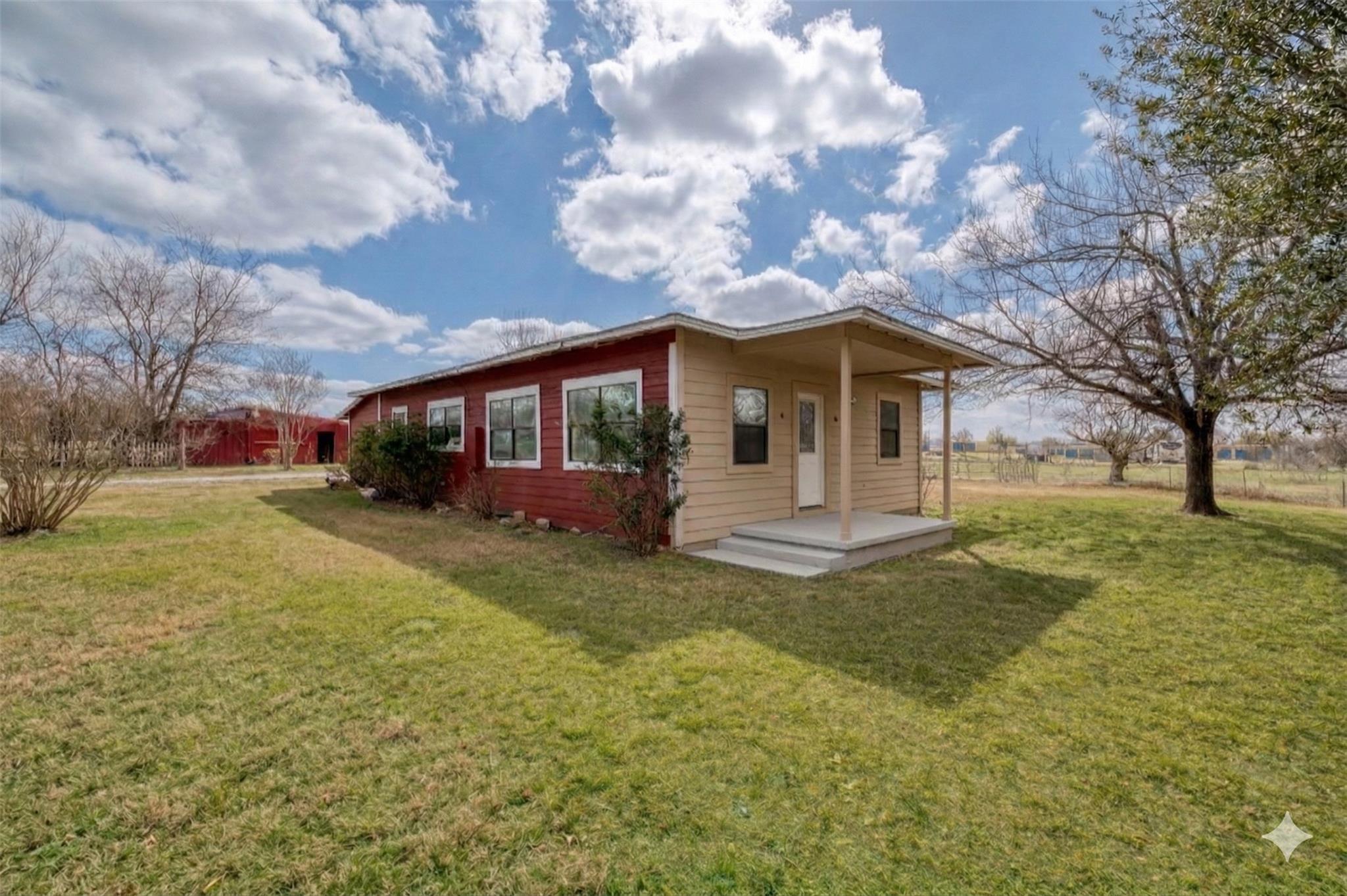 Rear view of house featuring a yard and a patio a