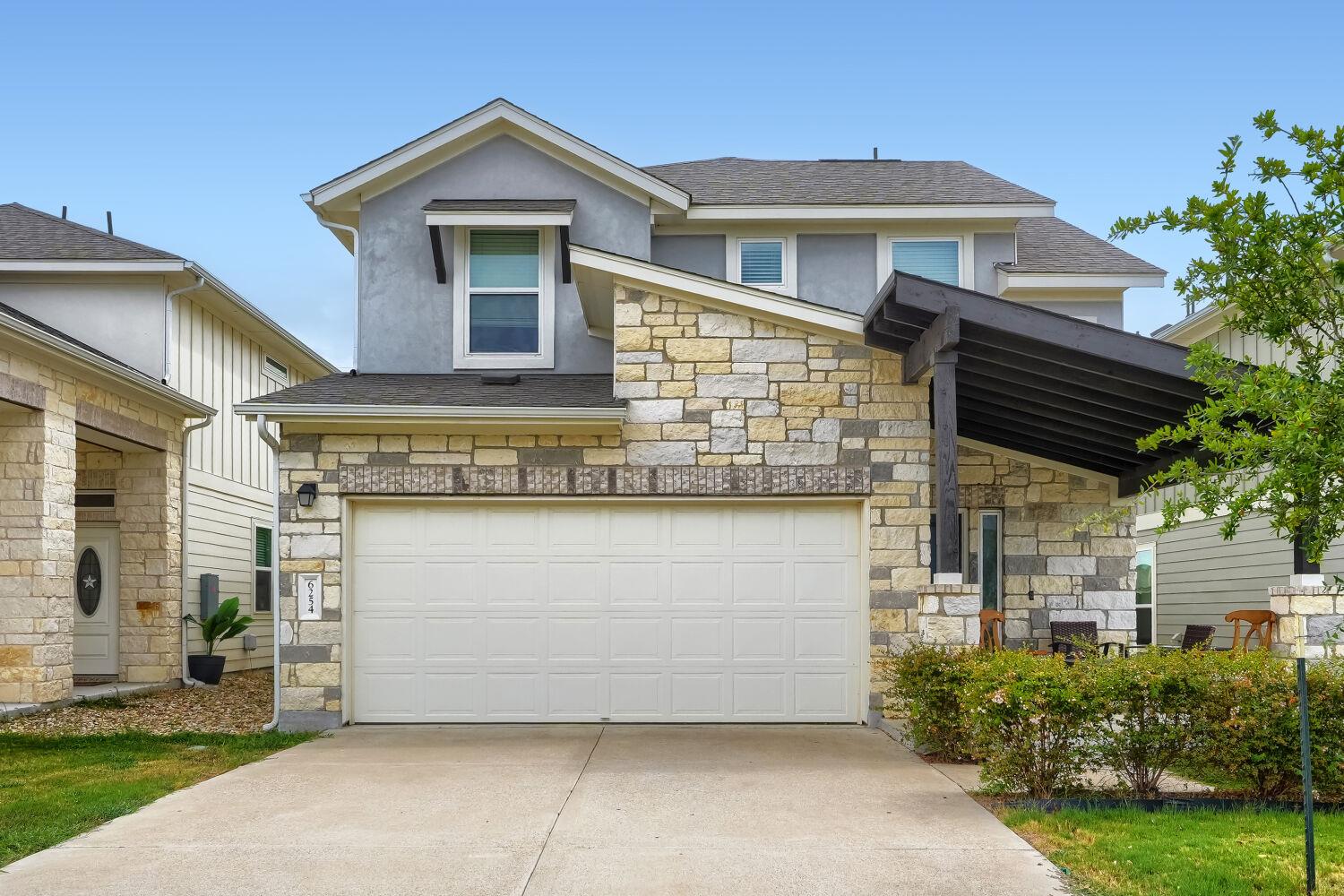 Natural stone accents and a covered porch enhance